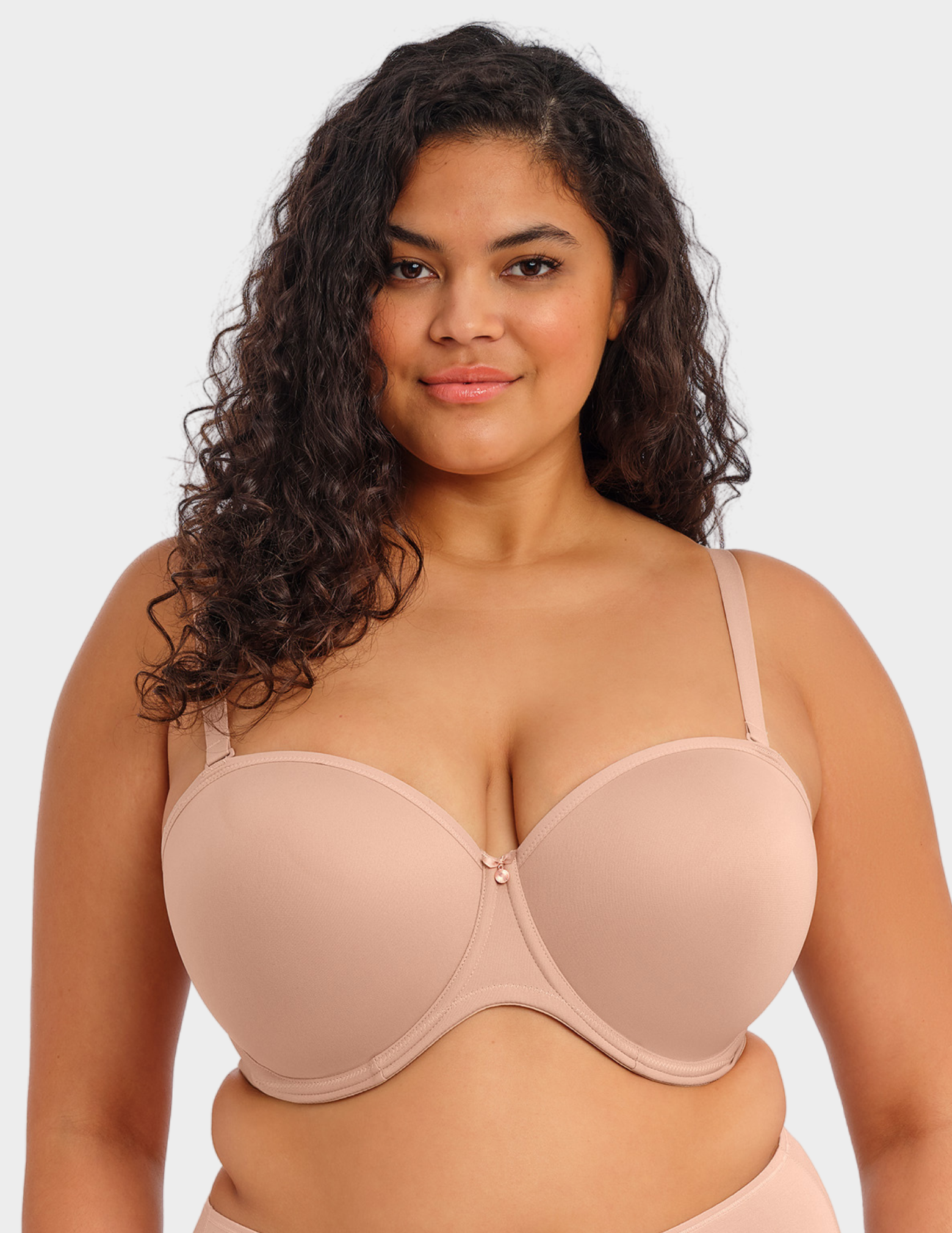Front view of a model wearing Elomi Smooth strapless bra in Sahara with straps attached