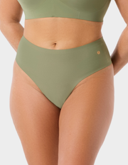 Front view of a model wearing Evelyn & Bobbie Seamless Thong in Matcha