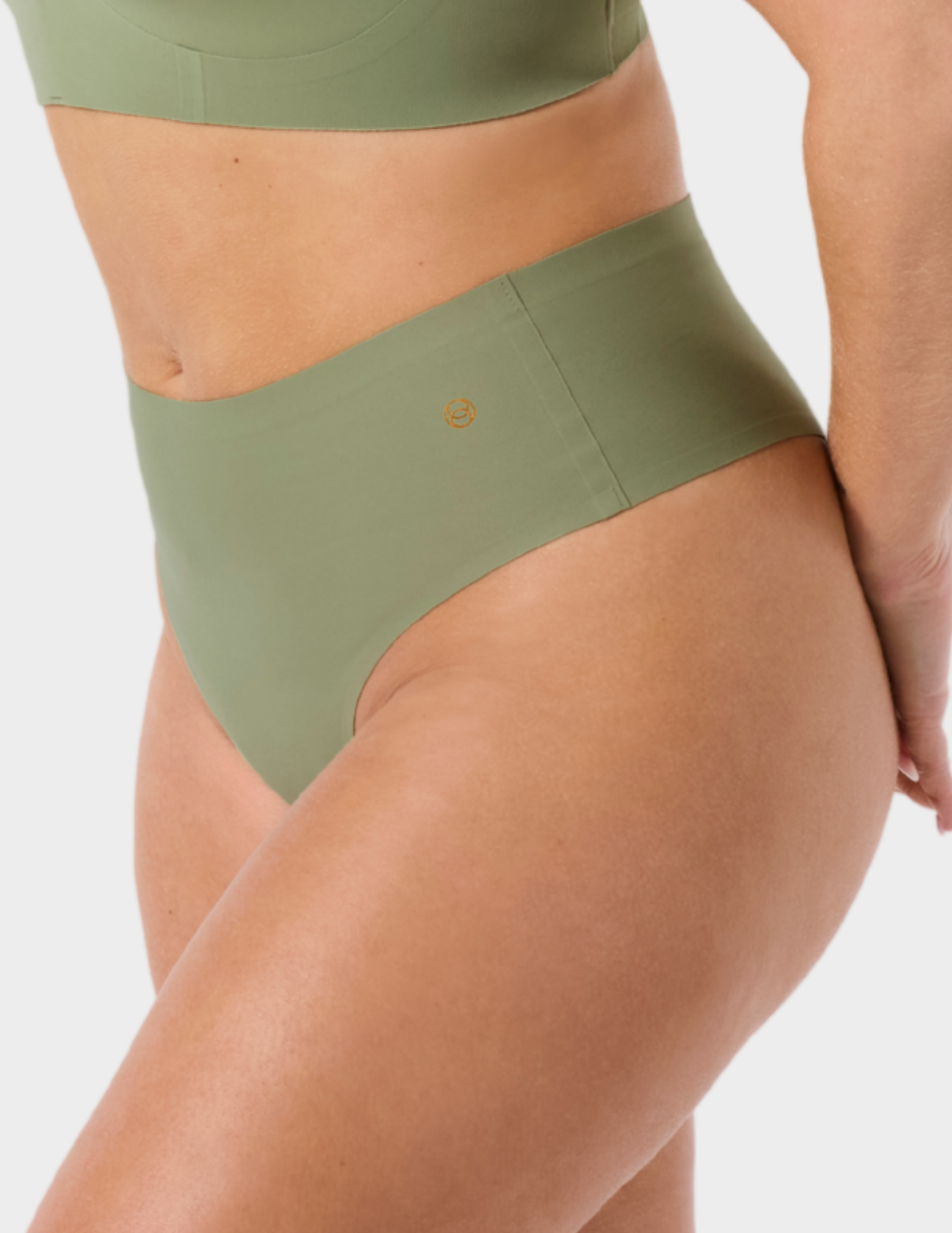 Side view of a model wearing Evelyn & Bobbie Seamless Thong in Matcha