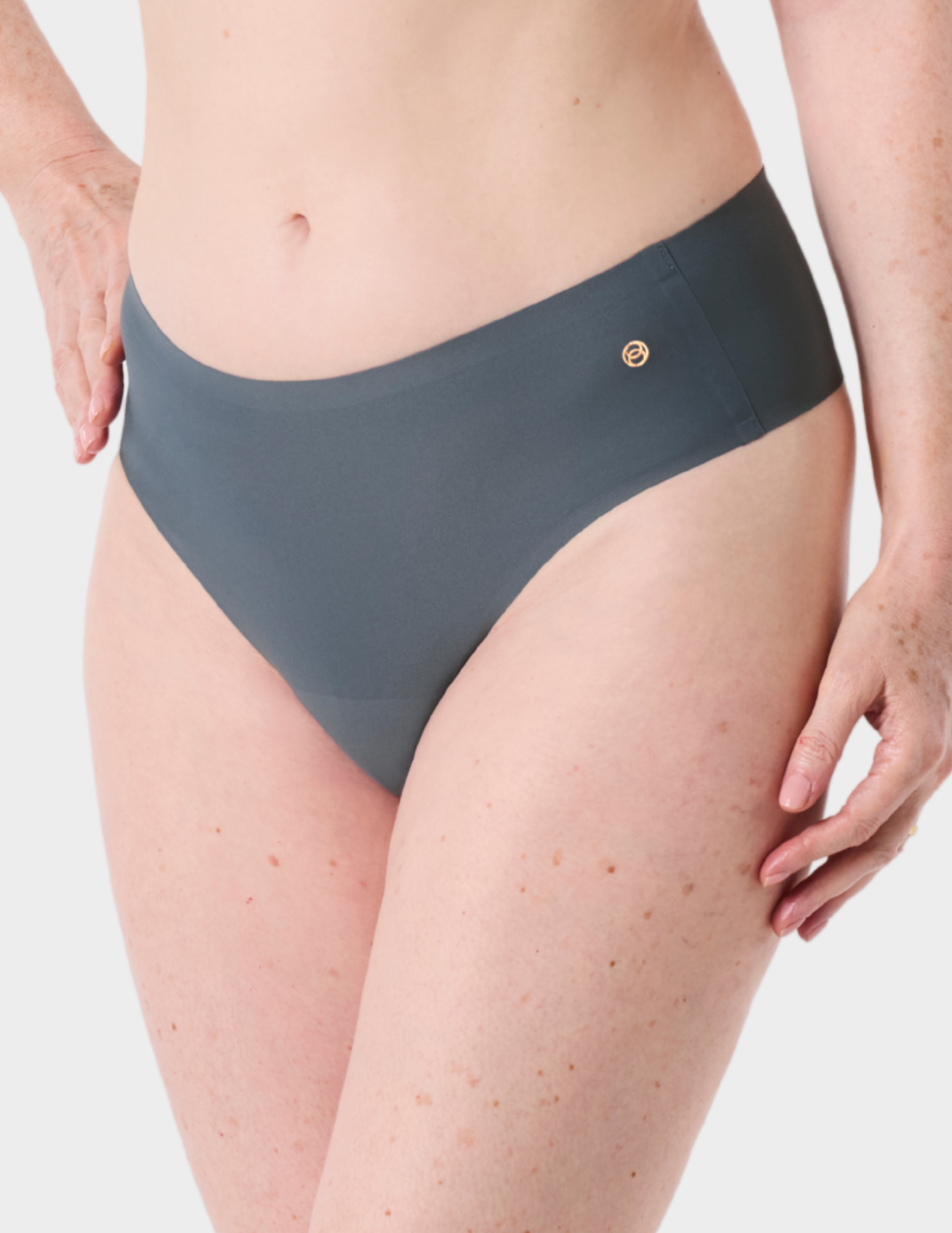 Side view of a model wearing Evelyn & Bobbie Seamless Thong in Slate Grey