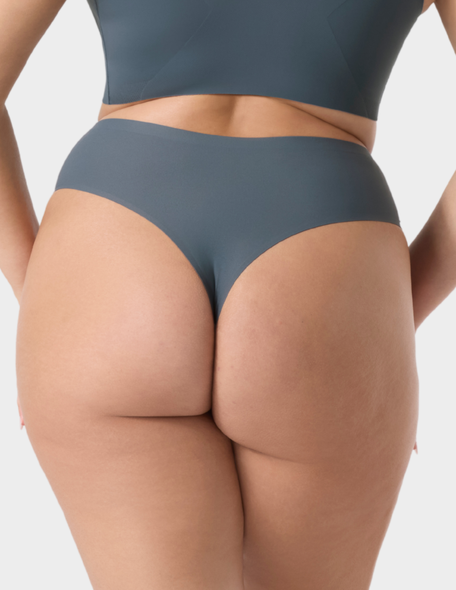 Back view of a model wearing Evelyn & Bobbie Seamless Thong in Slate Grey
