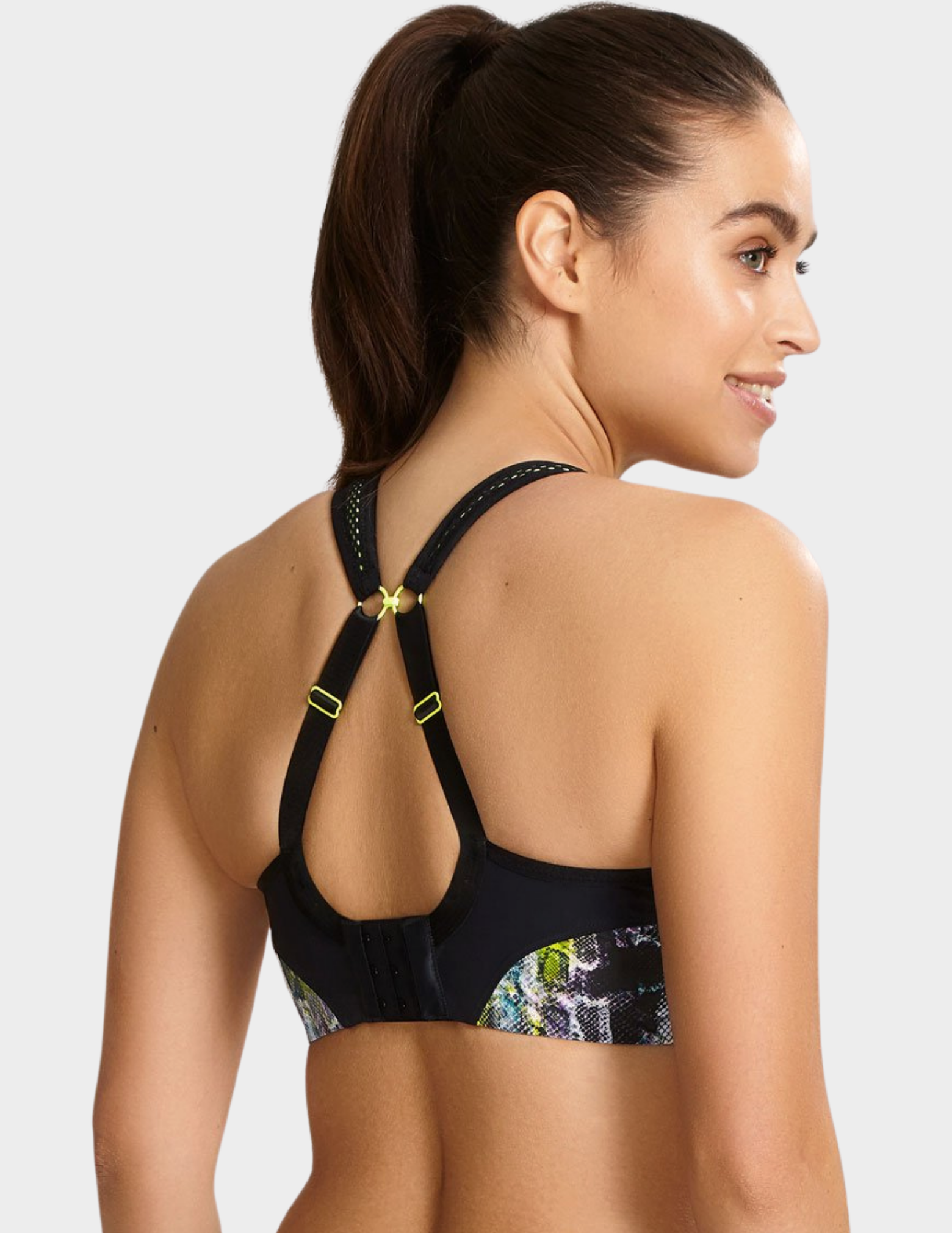 Back view of a model wearing Panache Non wired sports bra in Neon Reptile with straps hooked