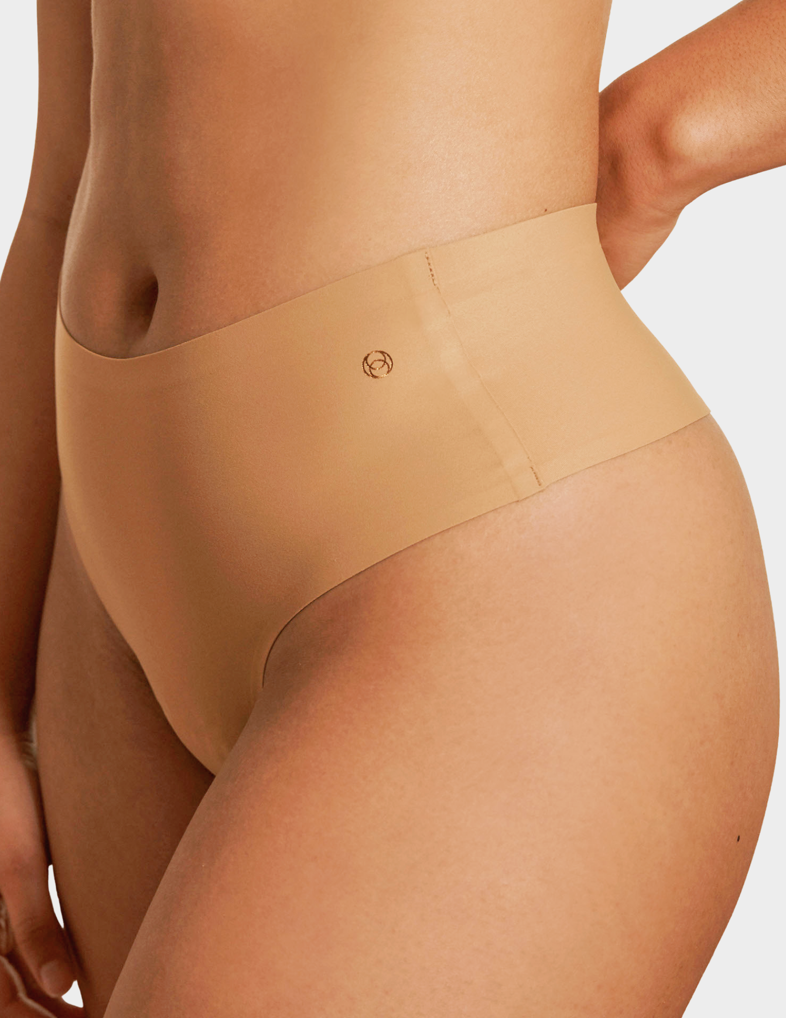 Side view of a model wearing Evelyn & Bobbie Seamless Thong in Mica