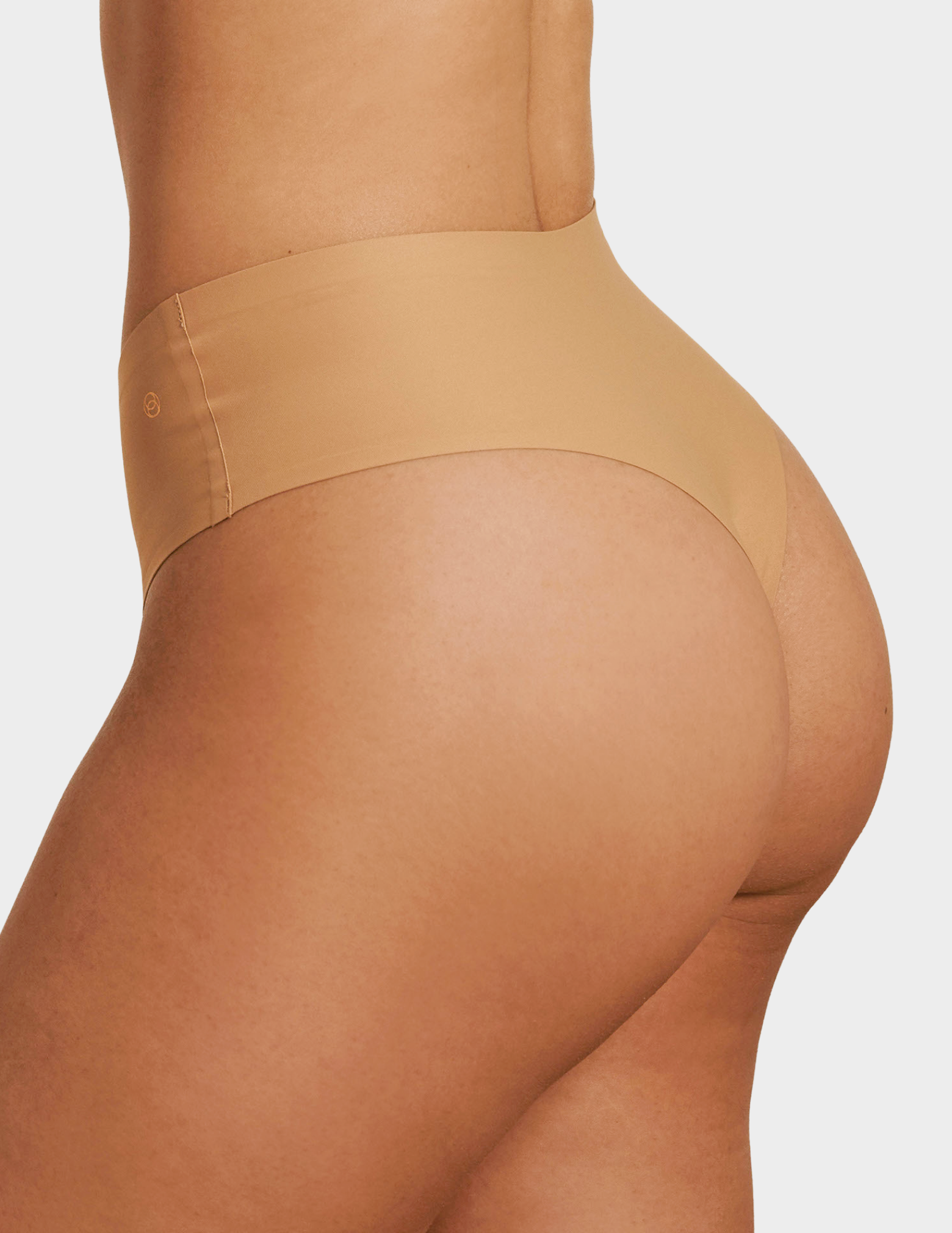 Side view of a model wearing Evelyn & Bobbie Seamless Thong in Mica