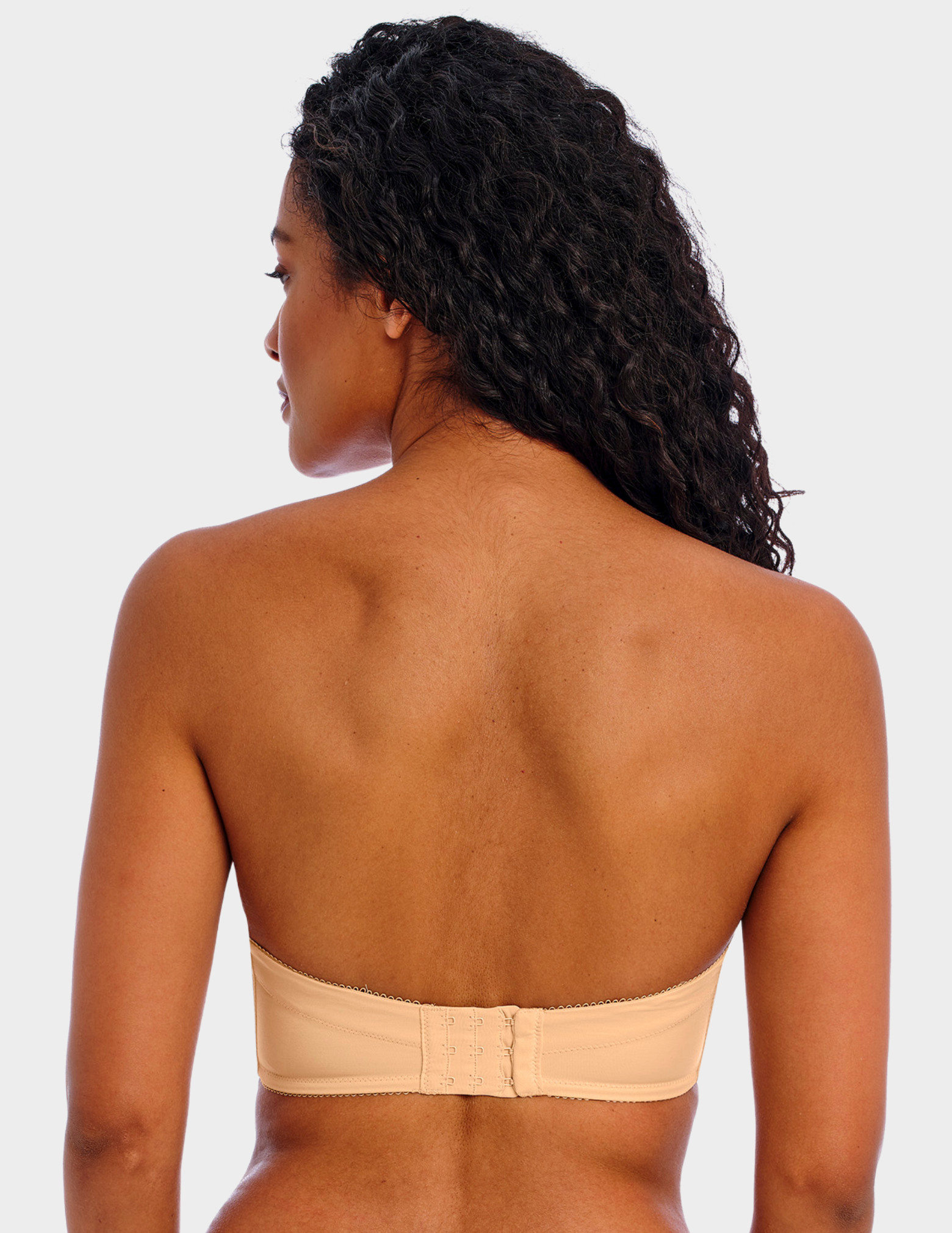 Back view of a model wearing Freya Deco strapless bra in Nude