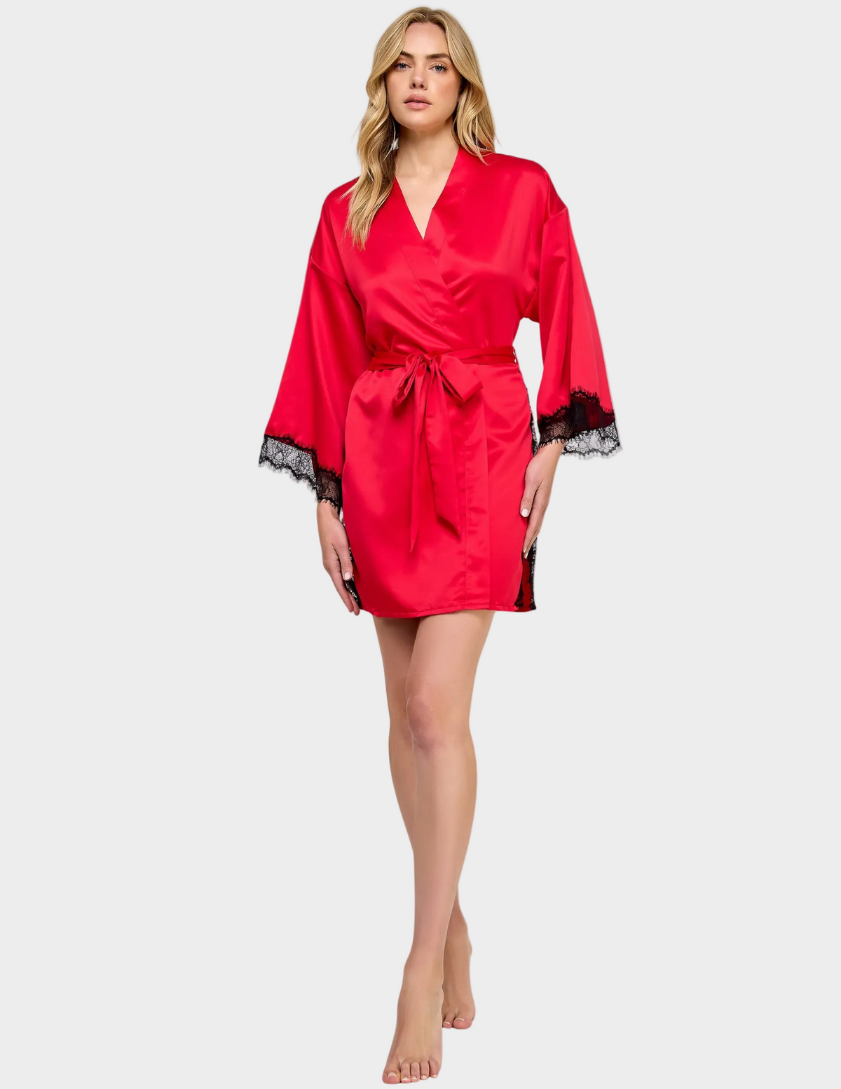 Front view of a model wearing a red satin robe with black lace trim