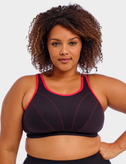 Front view of a model wearing Goddess Synergy sports bra in black