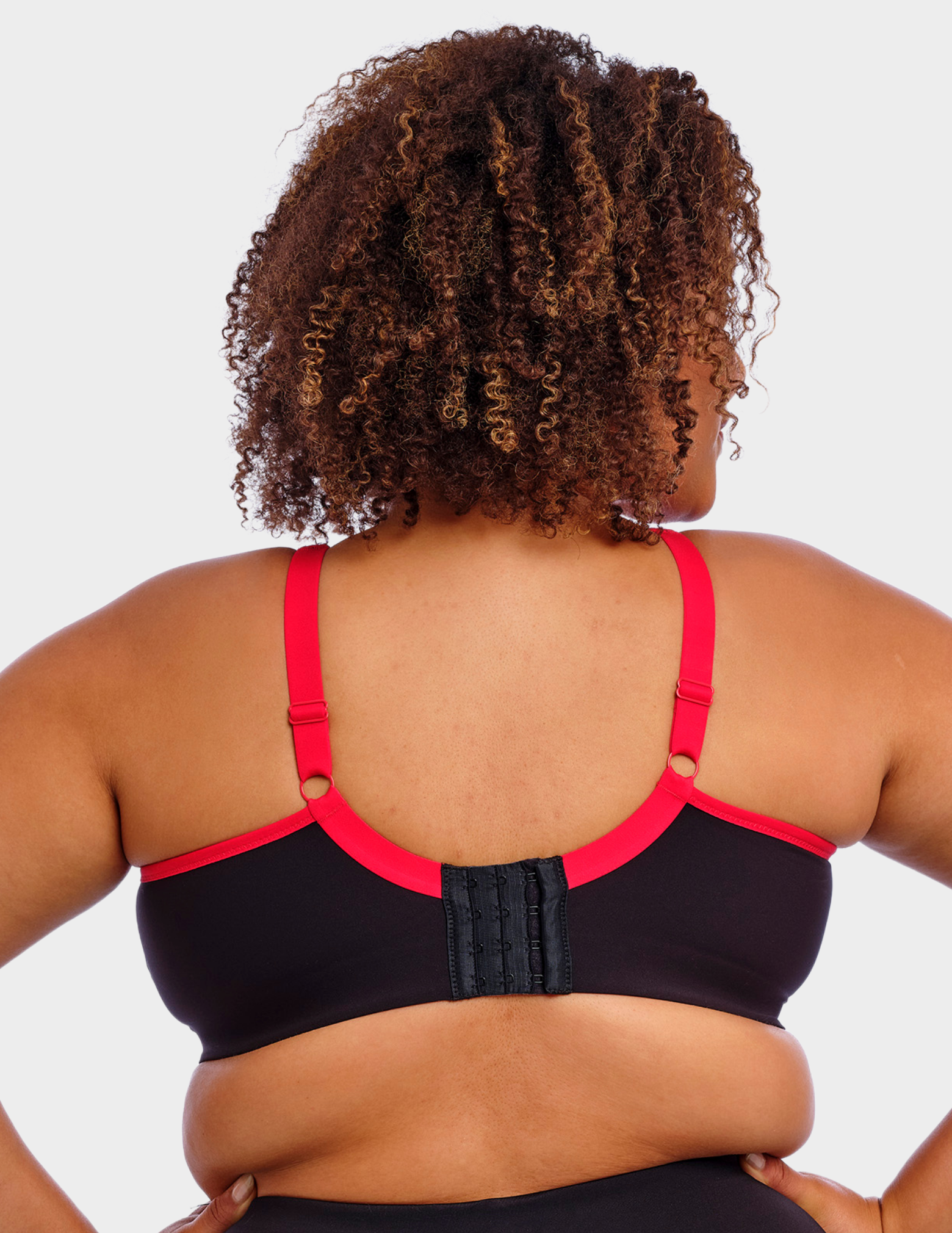Back view of a model wearing Goddess Synergy sports bra in black