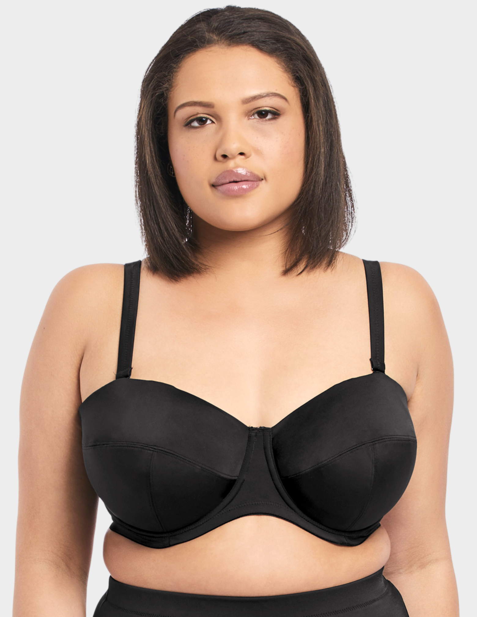 Front view of a model wearing Elomi Essentials bandeau bikini top in black with straps