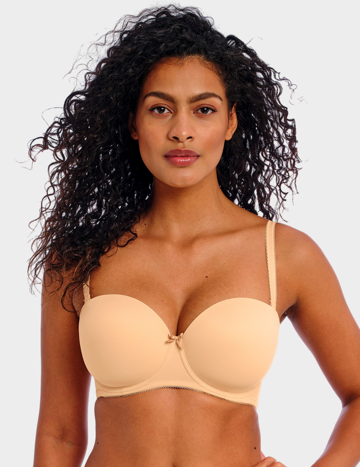 Front view of a model wearing Freya Deco strapless bra in Nude with straps attached