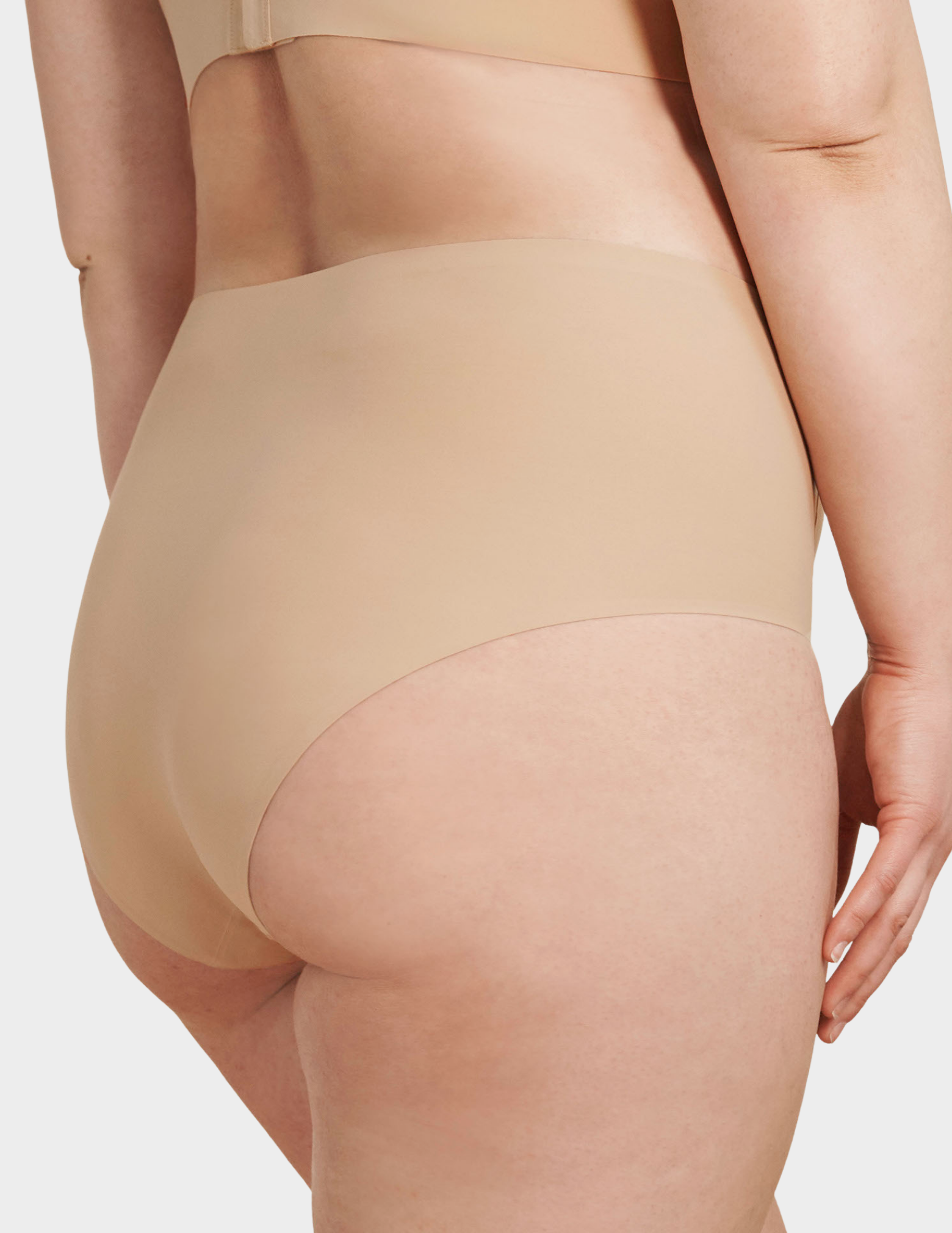 Back view of a model wearing Evelyn & Bobbie high waist brief in Sand