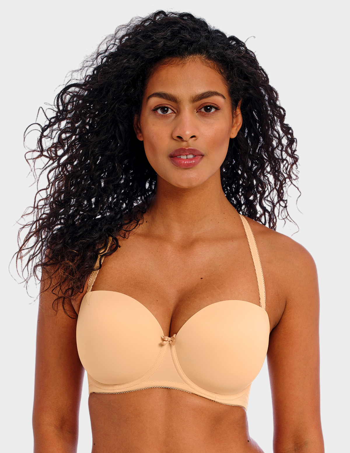 Front view of a model wearing Freya Deco strapless bra in Nude with straps attached