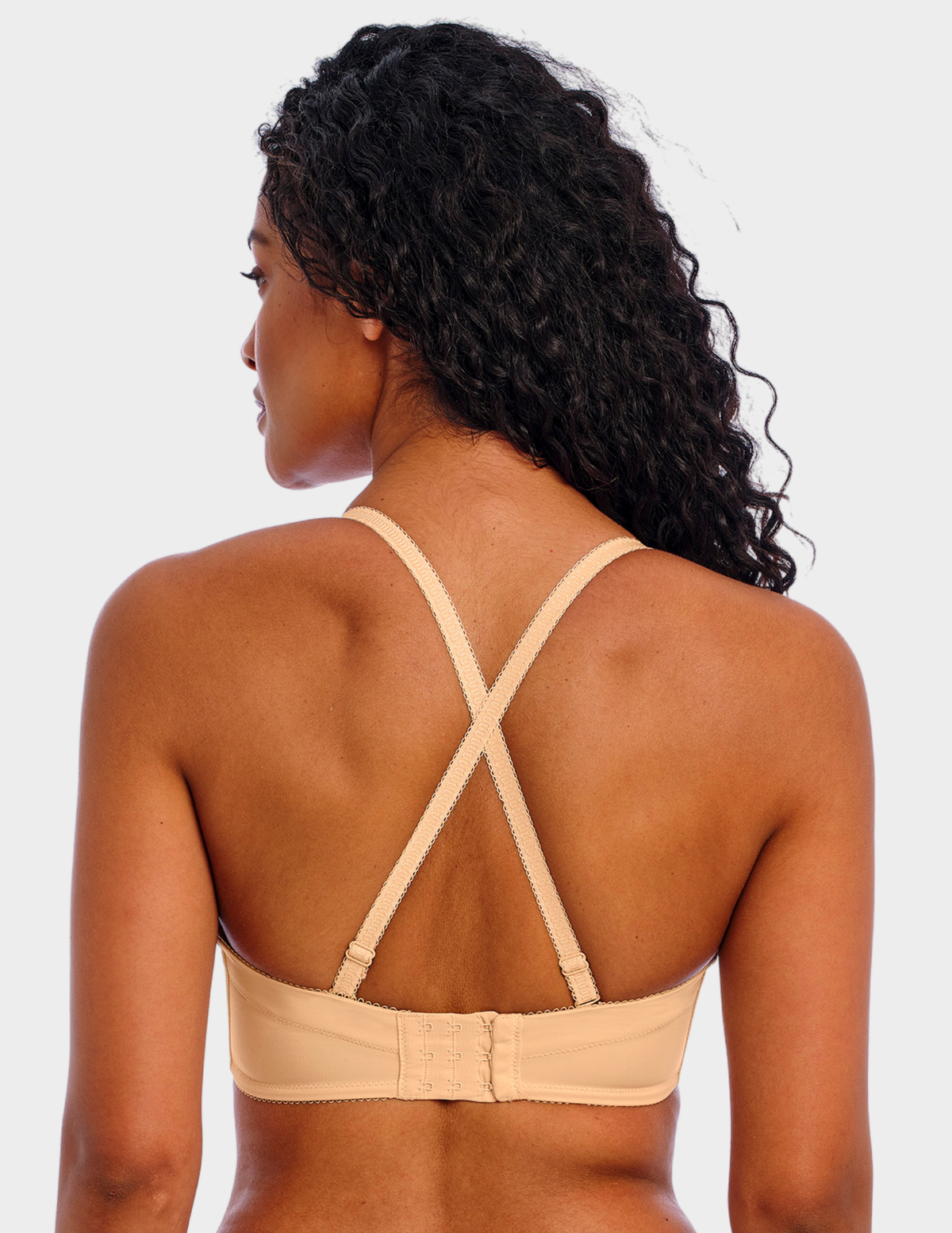 Back view of a model wearing Freya Deco strapless bra in Nude with straps crossed