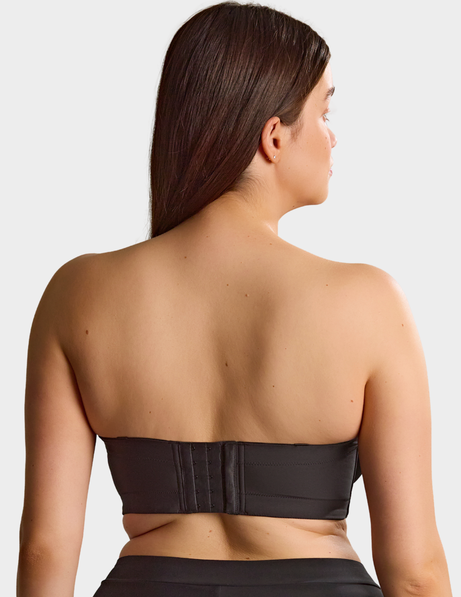 Back view of a model wearing Sculptresse Dana strapless bra in Black