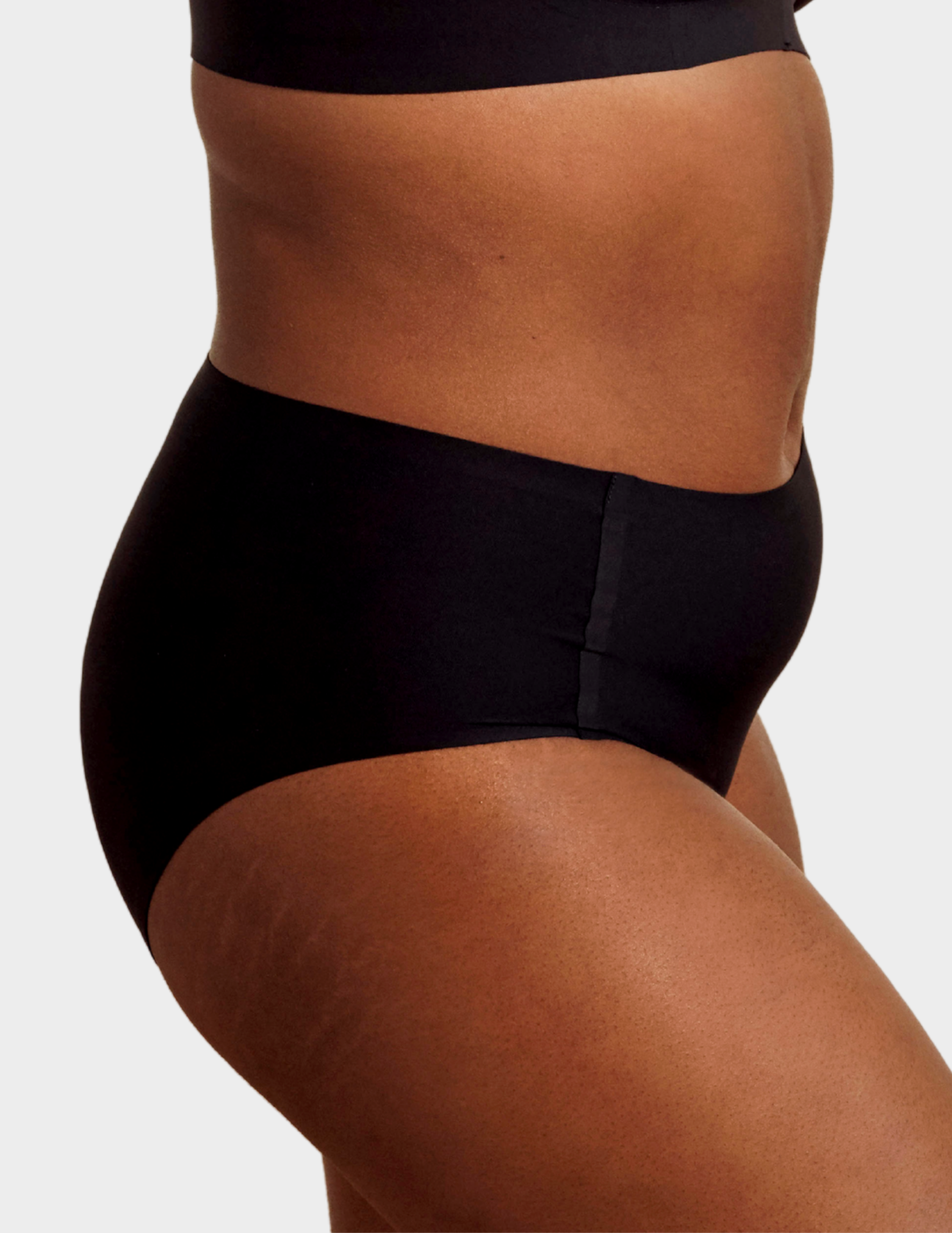 Side view of a model wearing Evelyn & Bobbie high waist brief in Black
