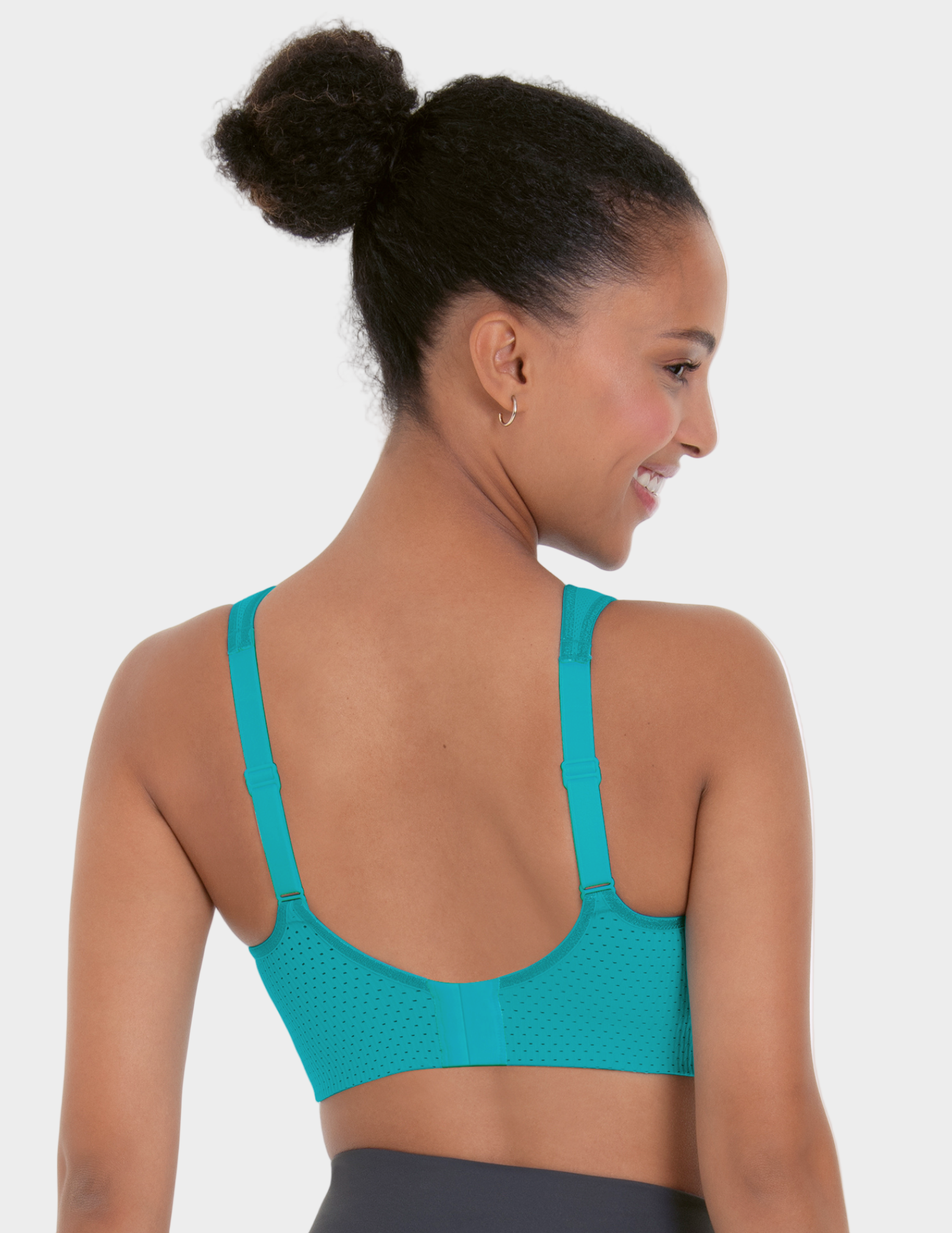 Woman wearing a teal sports bra on a white background