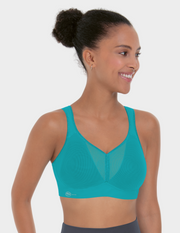 Woman wearing a teal sports bra on a white background
