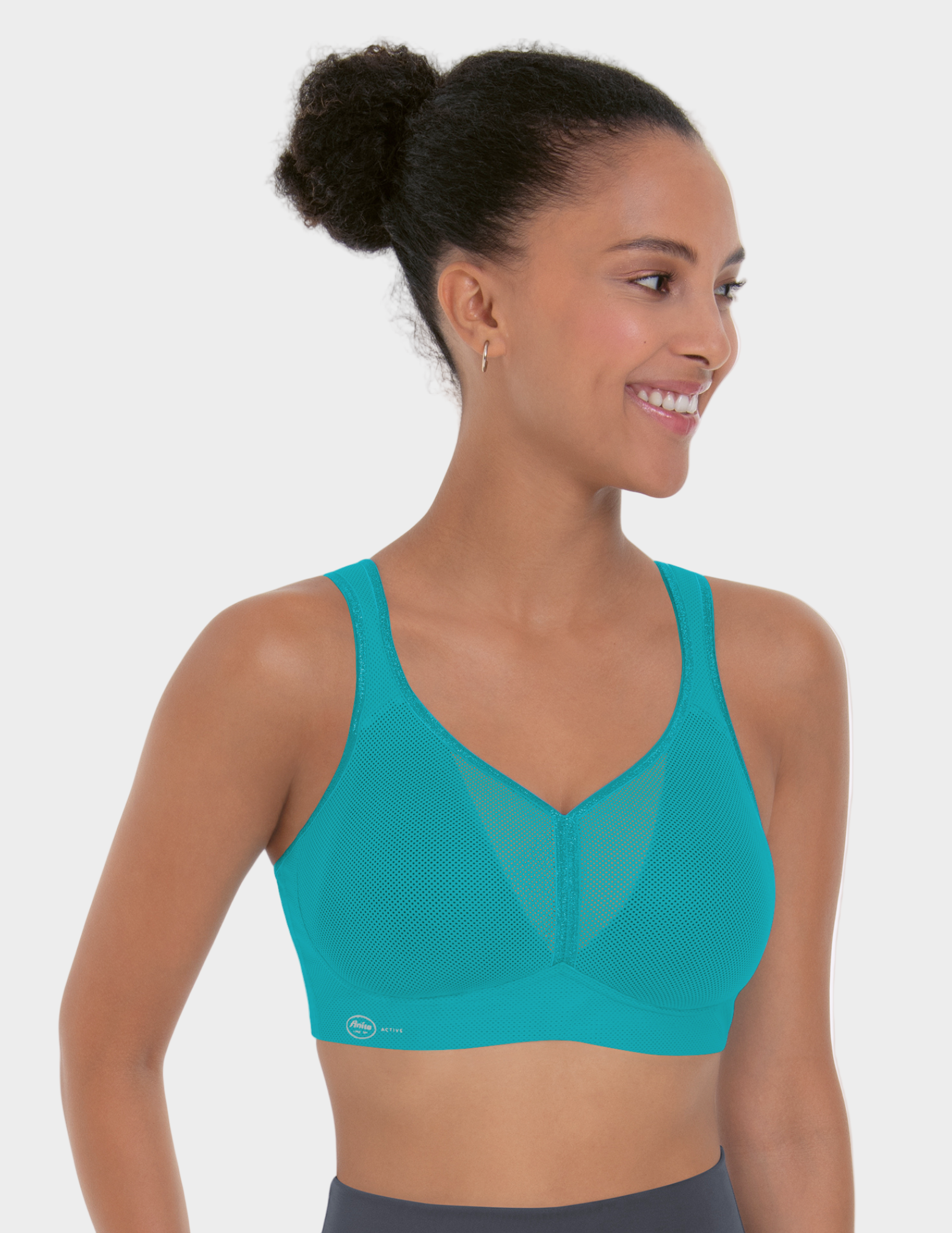 Woman wearing a teal sports bra on a white background