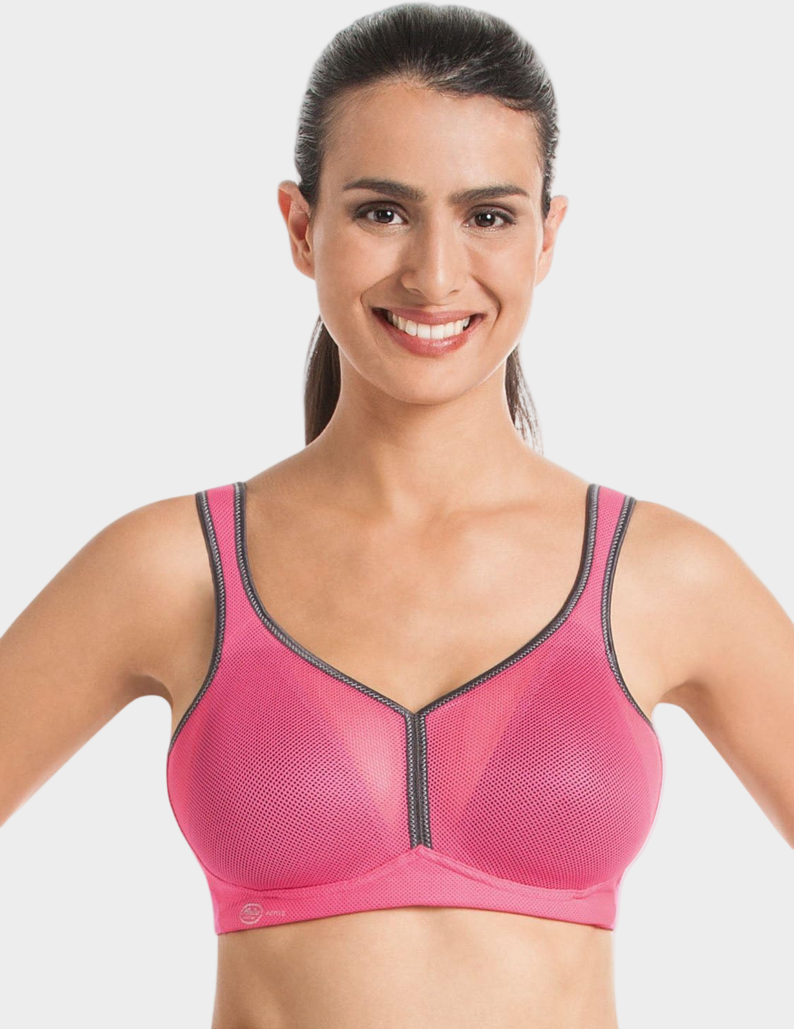 Woman wearing a pink sports bra with grey accents on a white background