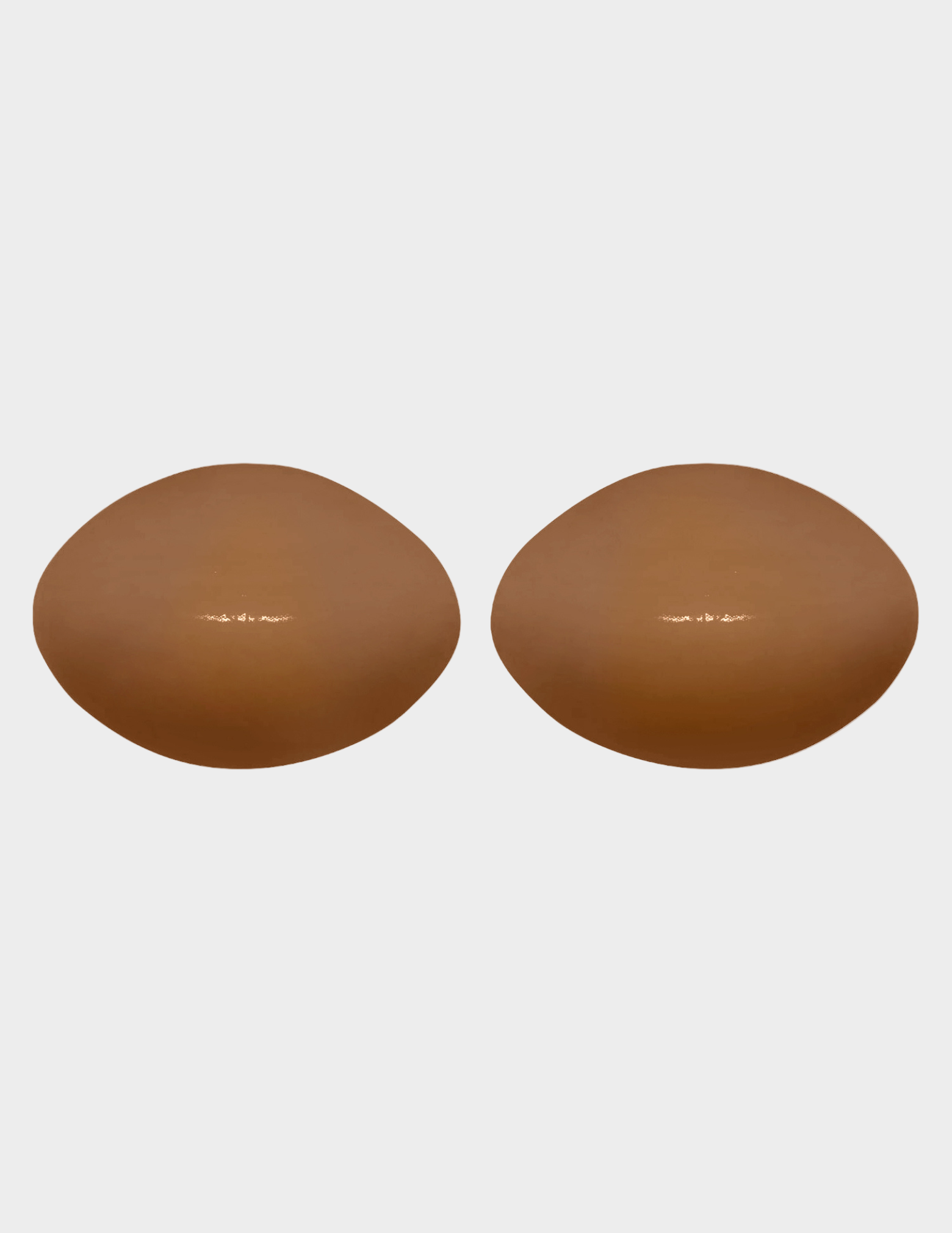 Pair of brown silicone bra inserts on a white background