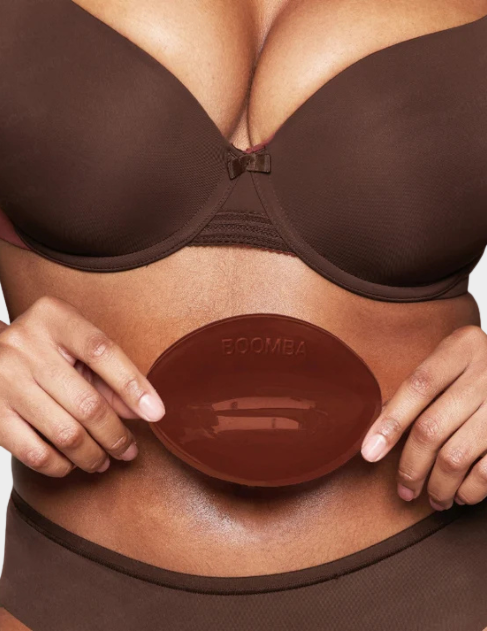 closeup of woman holding brown BOOMBA bra insert