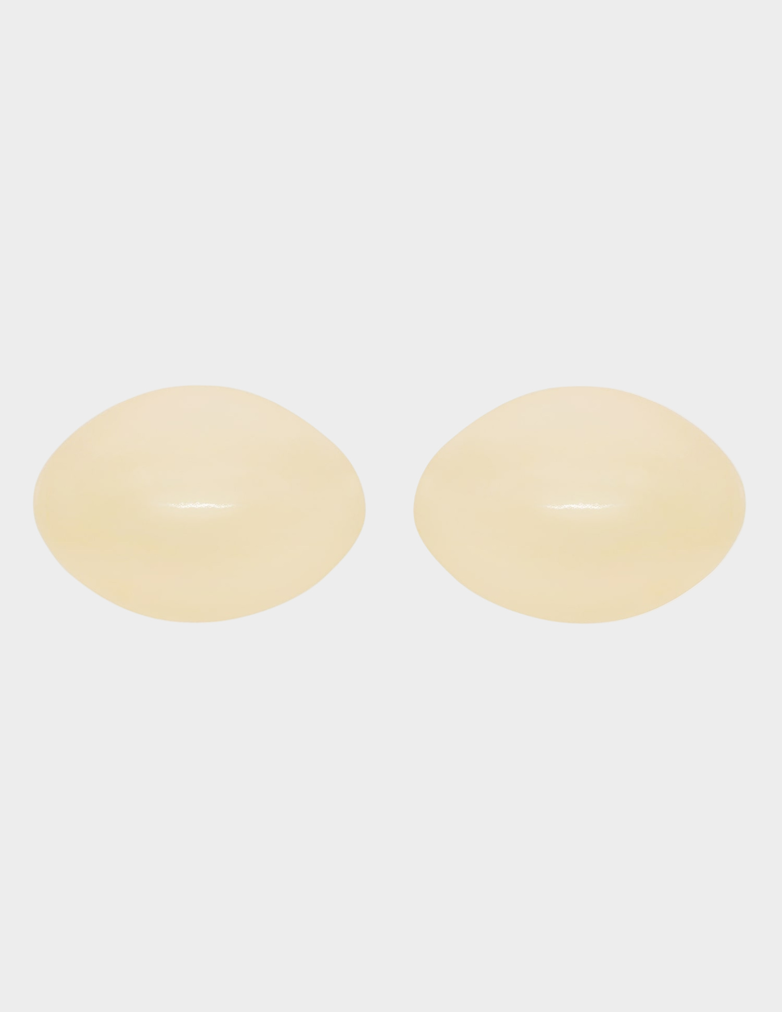 pair of beige bra inserts on white background
