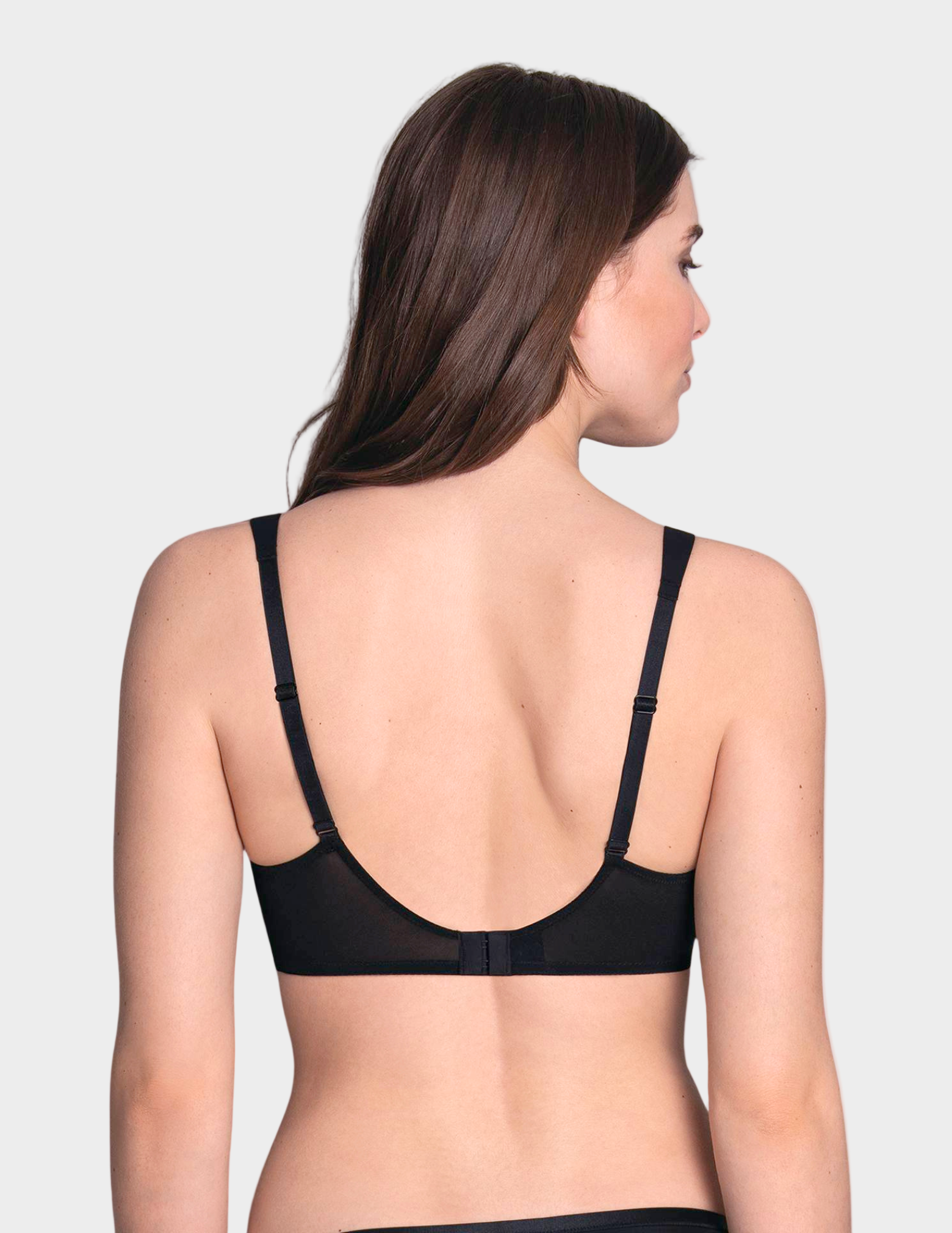 Woman wearing a black bra against a white background