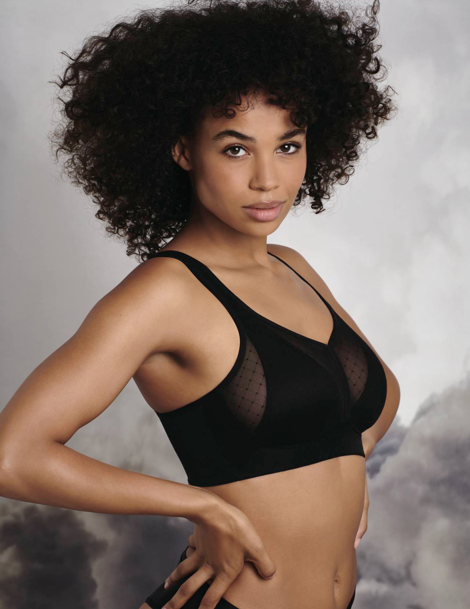 Woman wearing a black bra against a smoky background