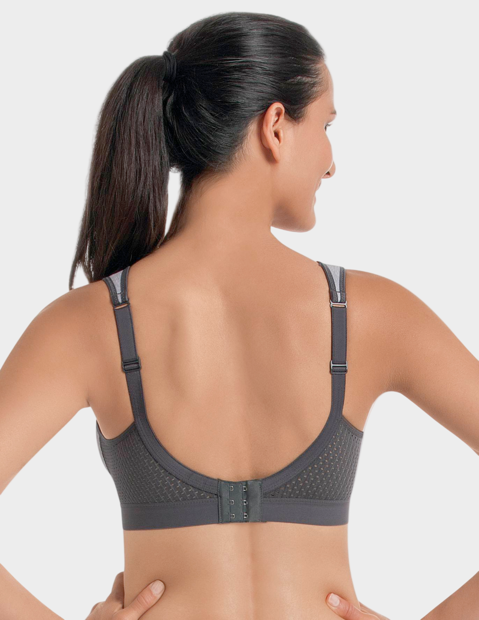 Woman wearing a gray sports bra on a white background