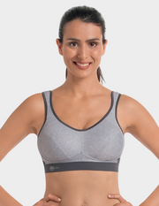 Woman wearing a gray sports bra against a white background