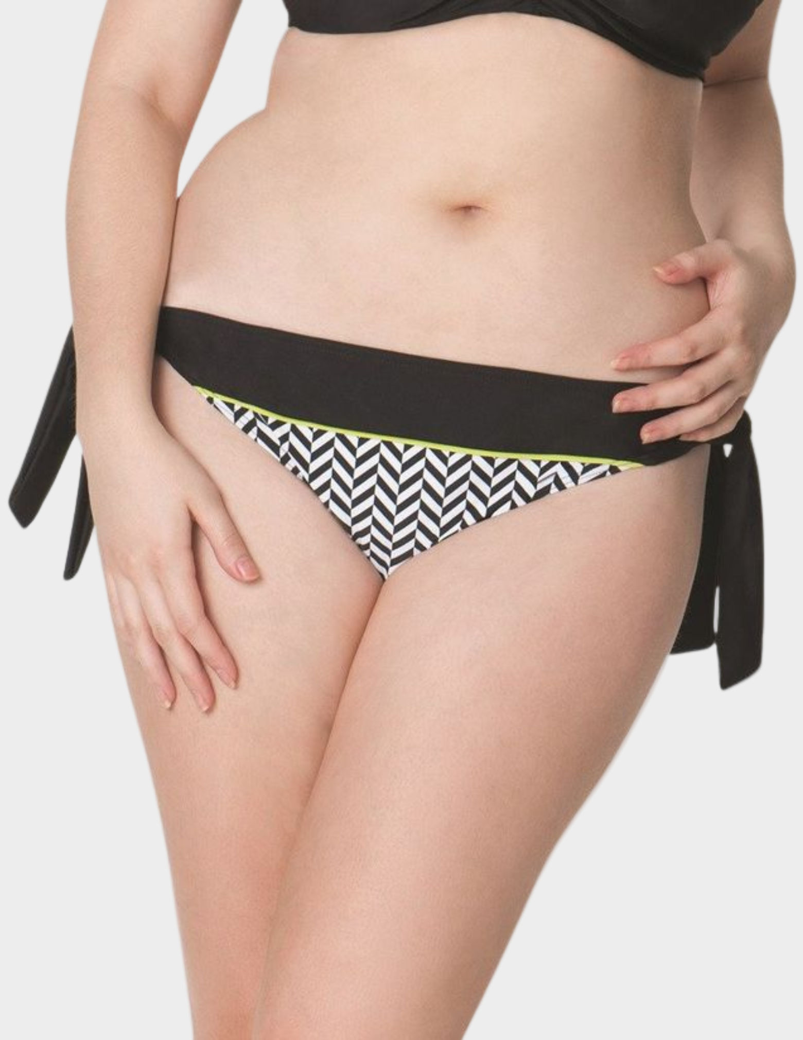 woman wearing black and white geometric print swim bottom with green accent and black tie sides