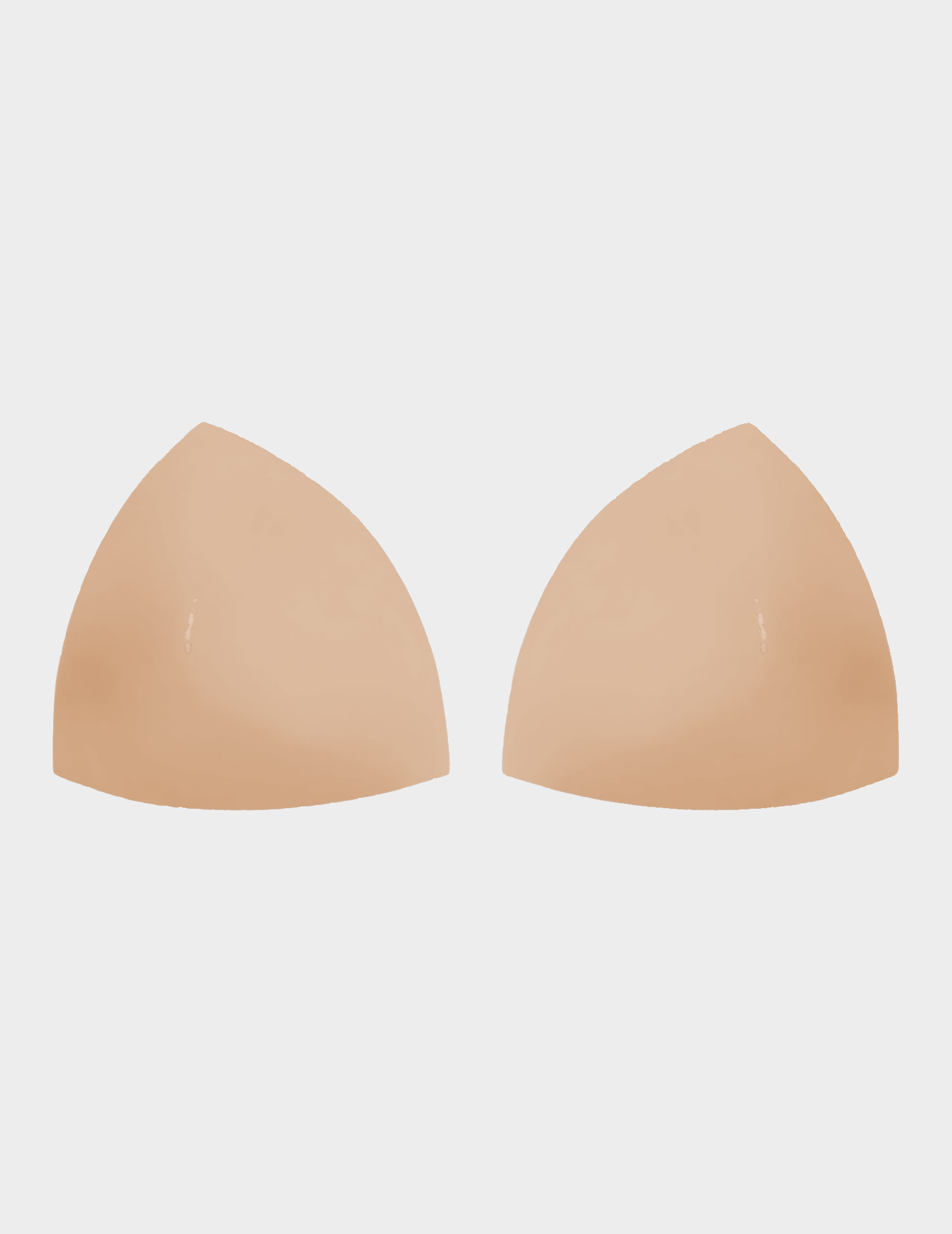 Beige silicone bra cups on a white background