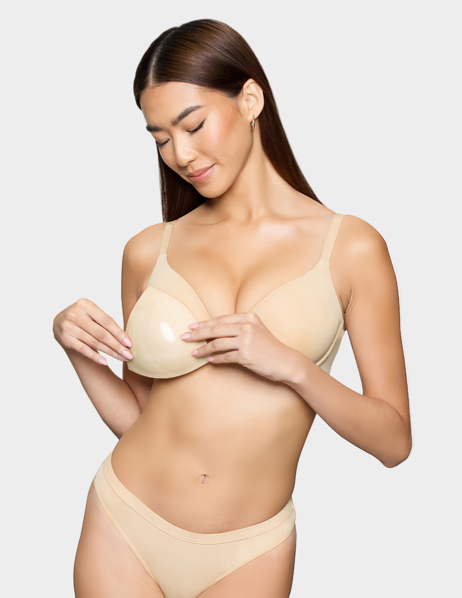 woman holding light beige bra insert