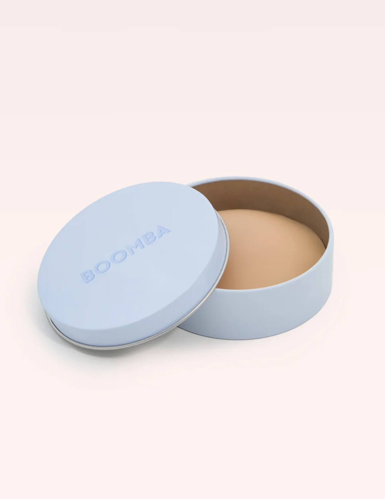 round blue container labeled BOOMBA with beige nipple cover inside