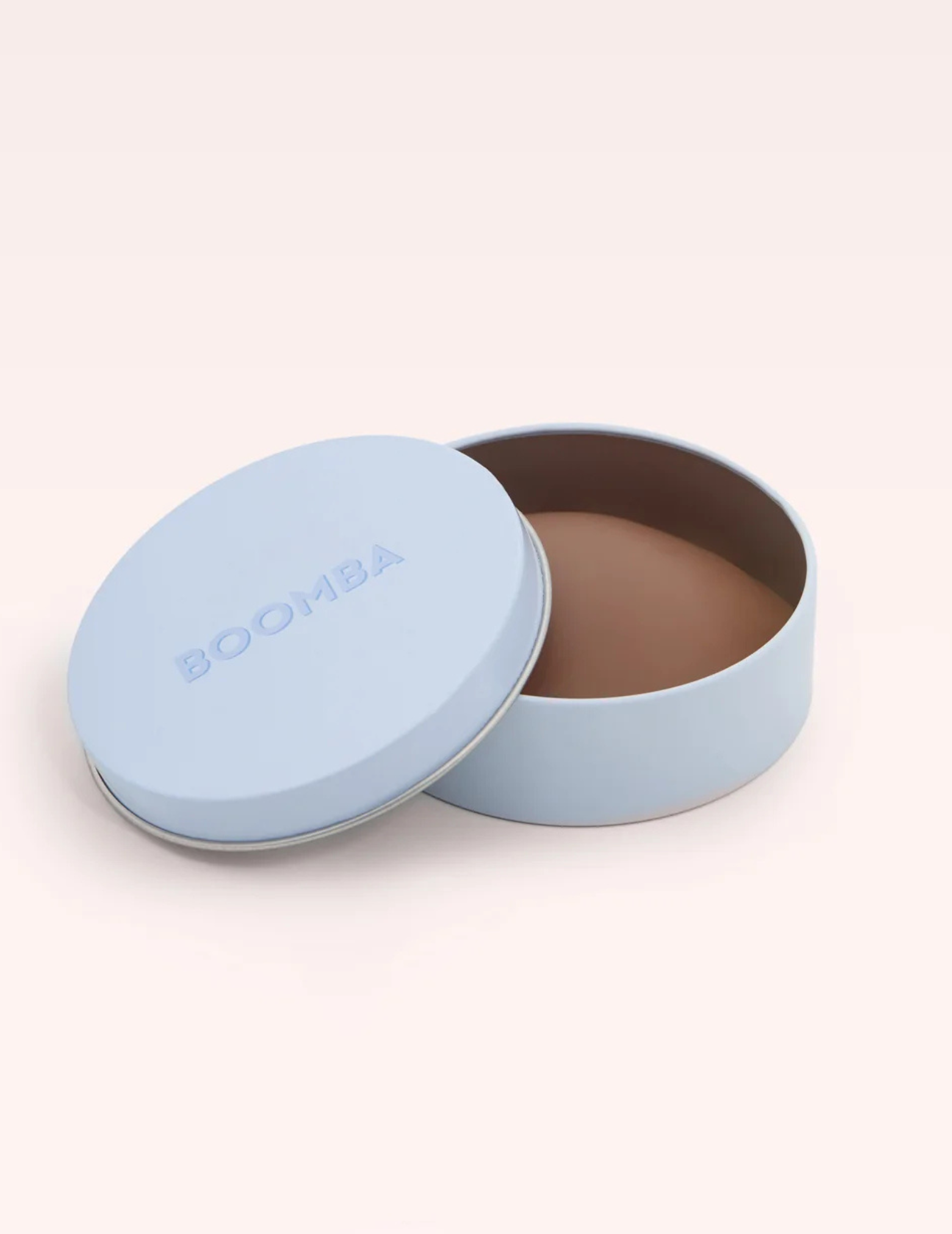 round blue container labeled Boomba with tan colored nipple cover inside