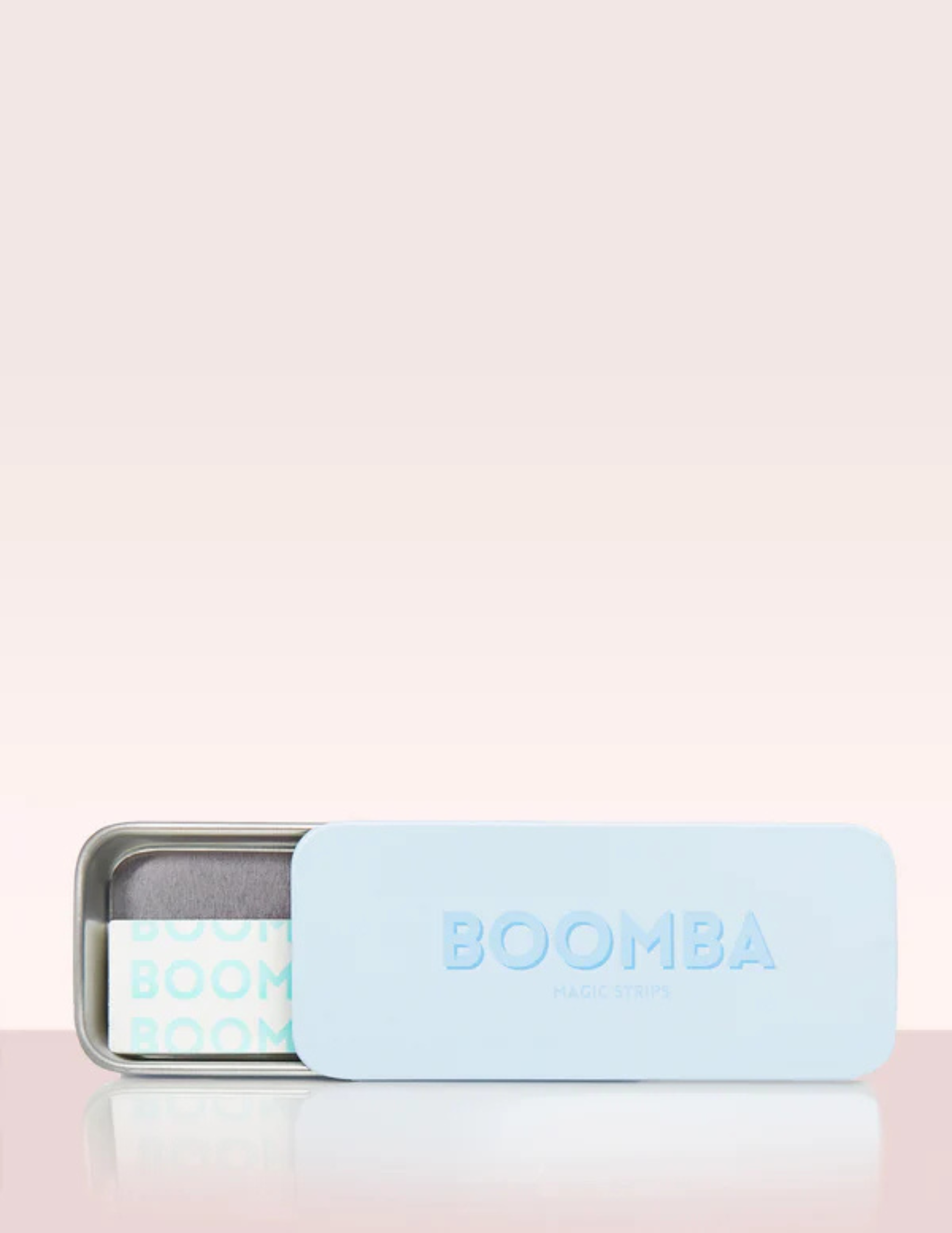 Open boomba magic strips tin with strips inside on pink backdrop