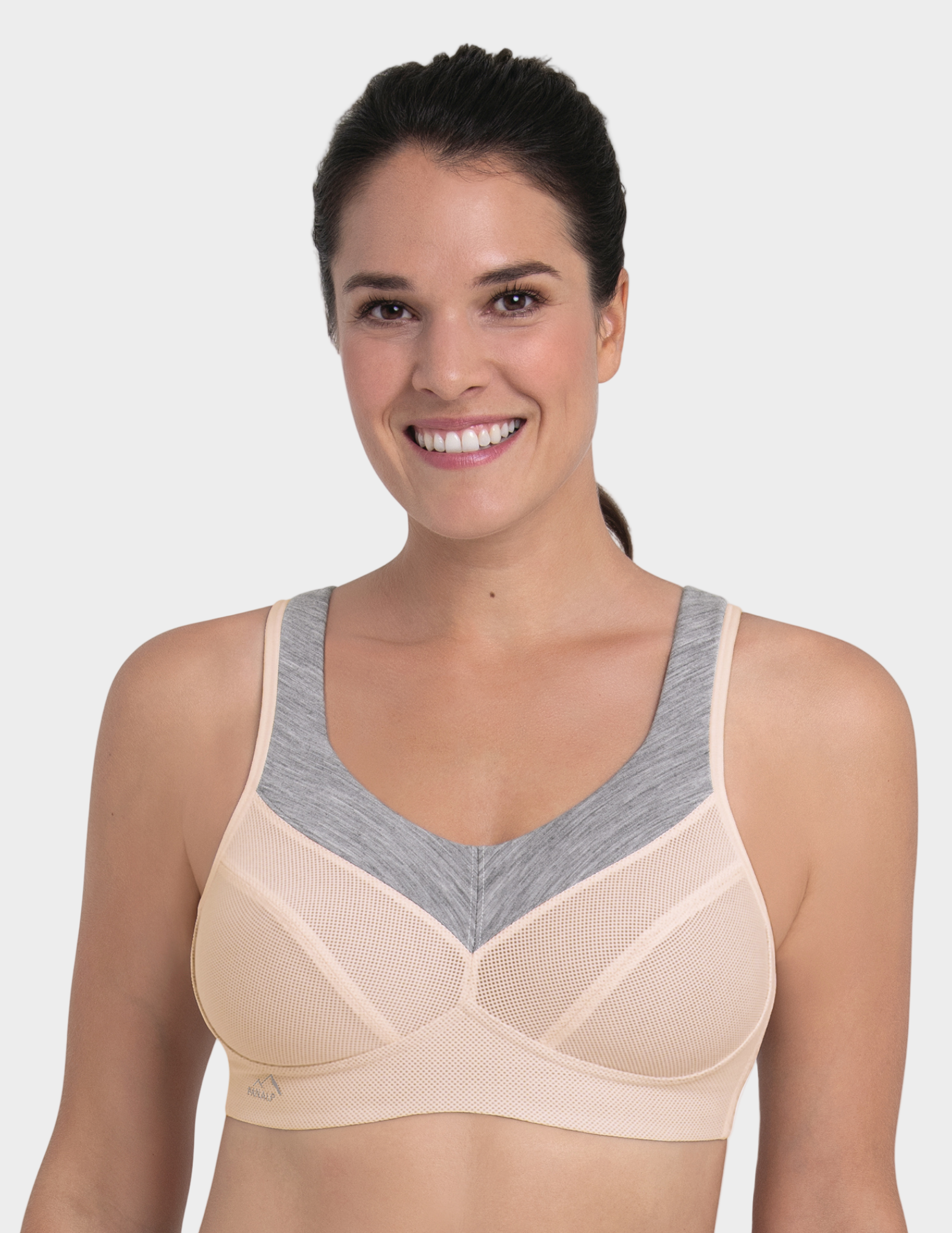 Woman wearing a beige and gray sports bra on a white background