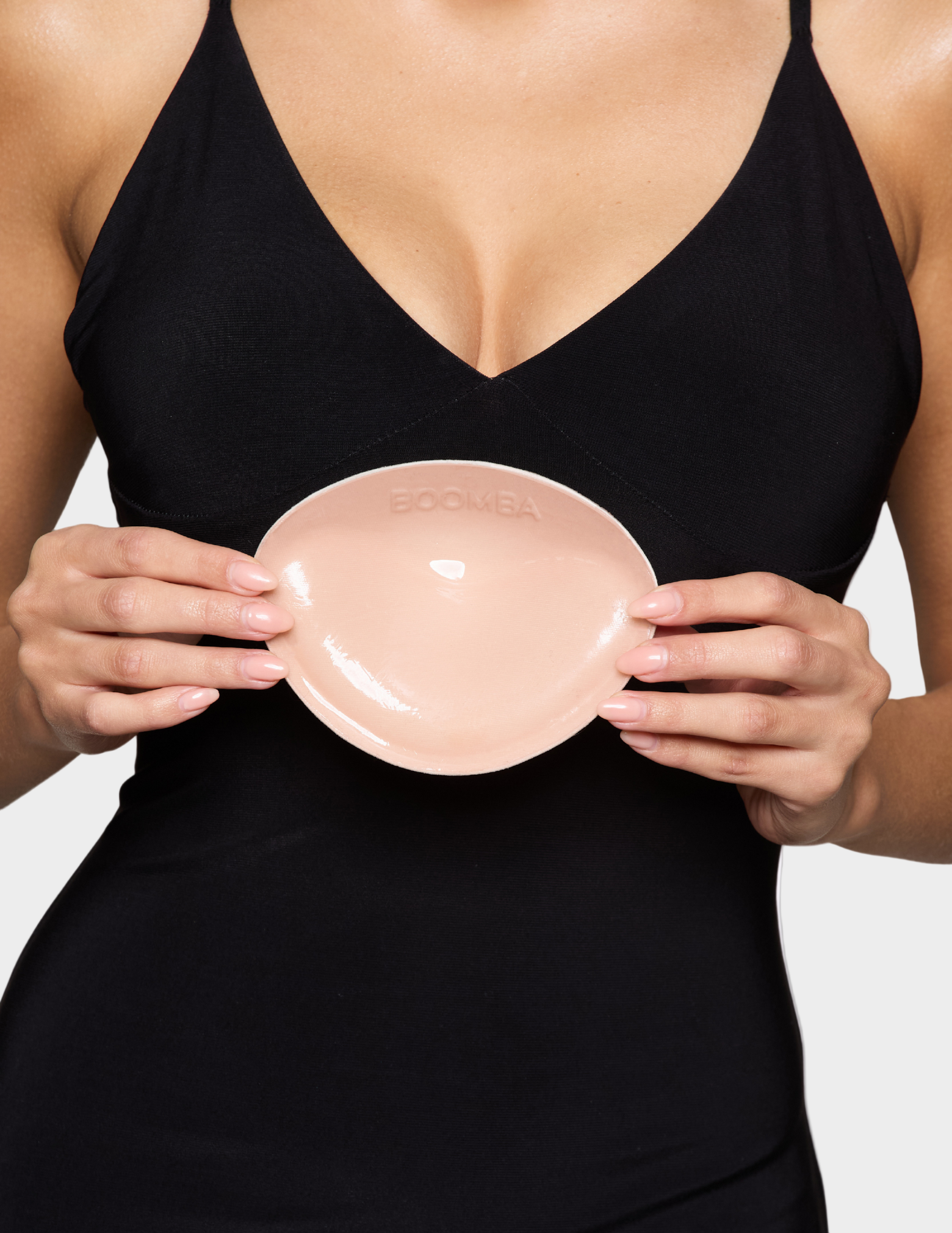 close up of woman holding padded beige bra insert