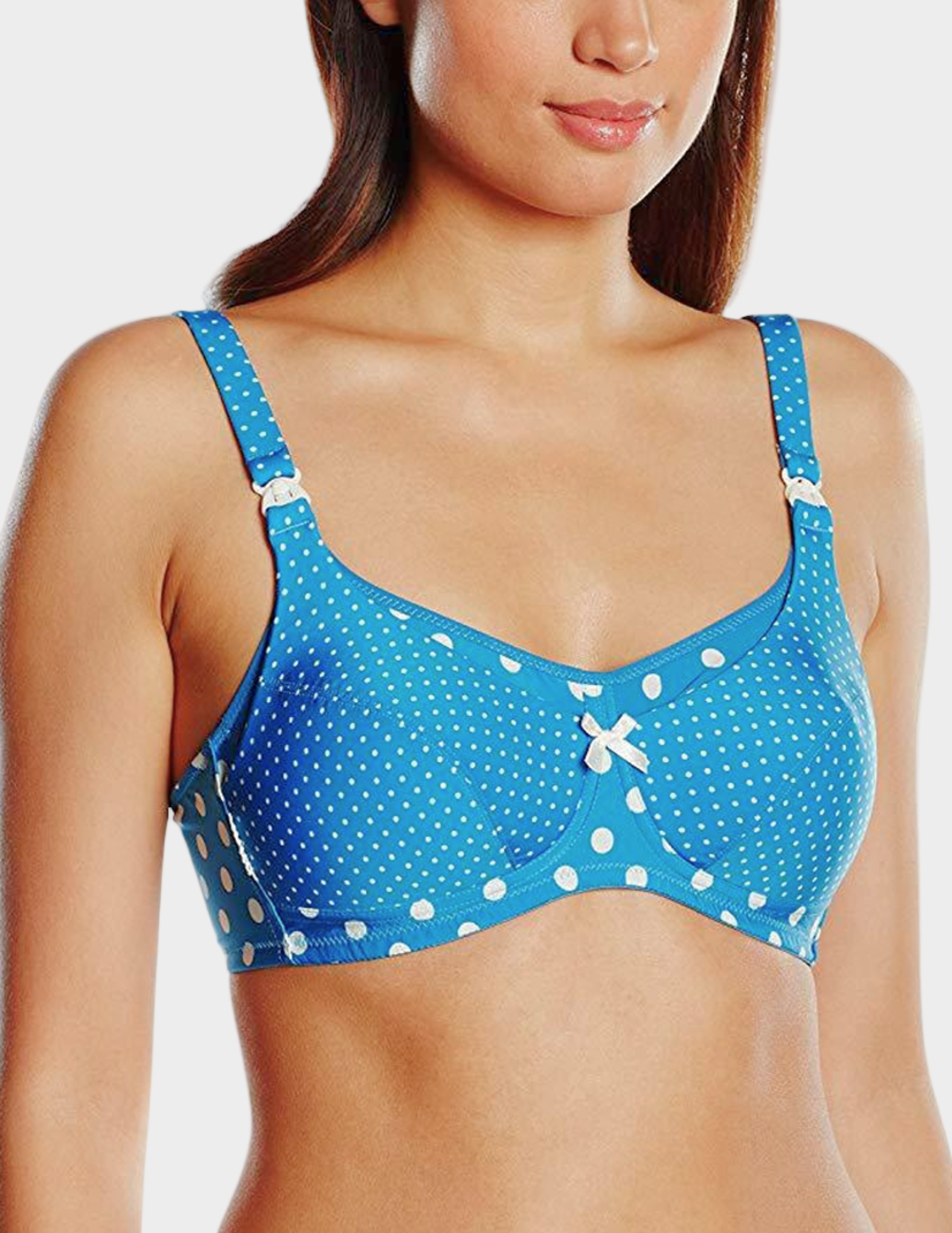 Woman wearing a blue polka dot nursing bra on a white background