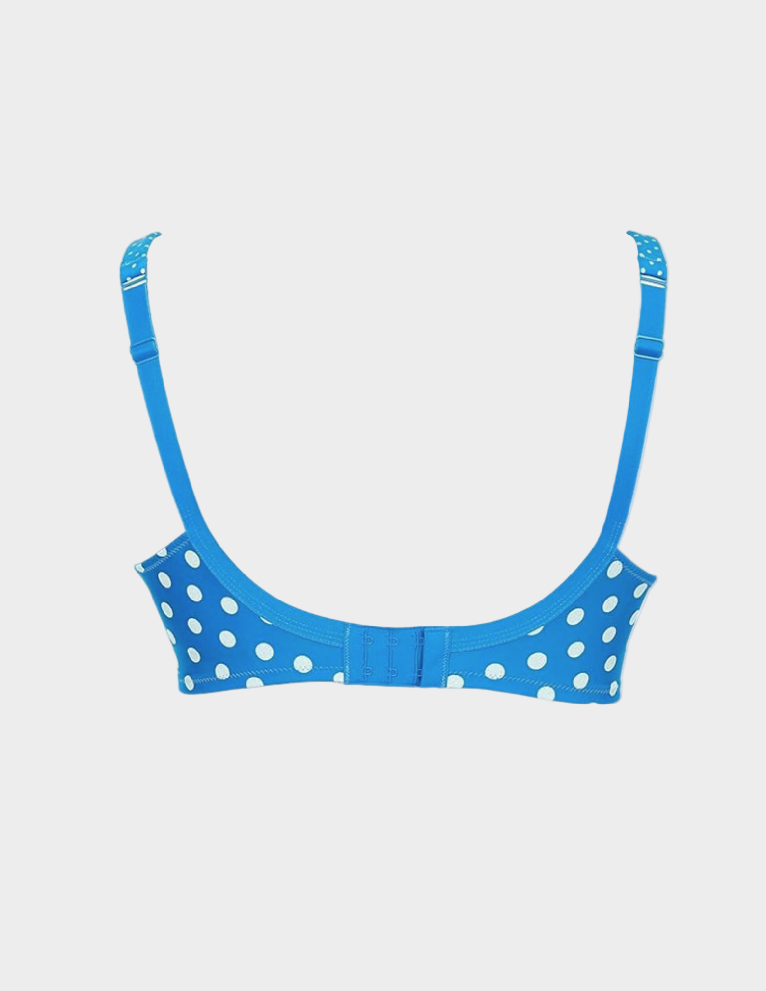 back view of Blue nursing bra with white polka dots on a light gray background