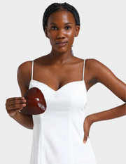 woman in white dress holding brown bra insert