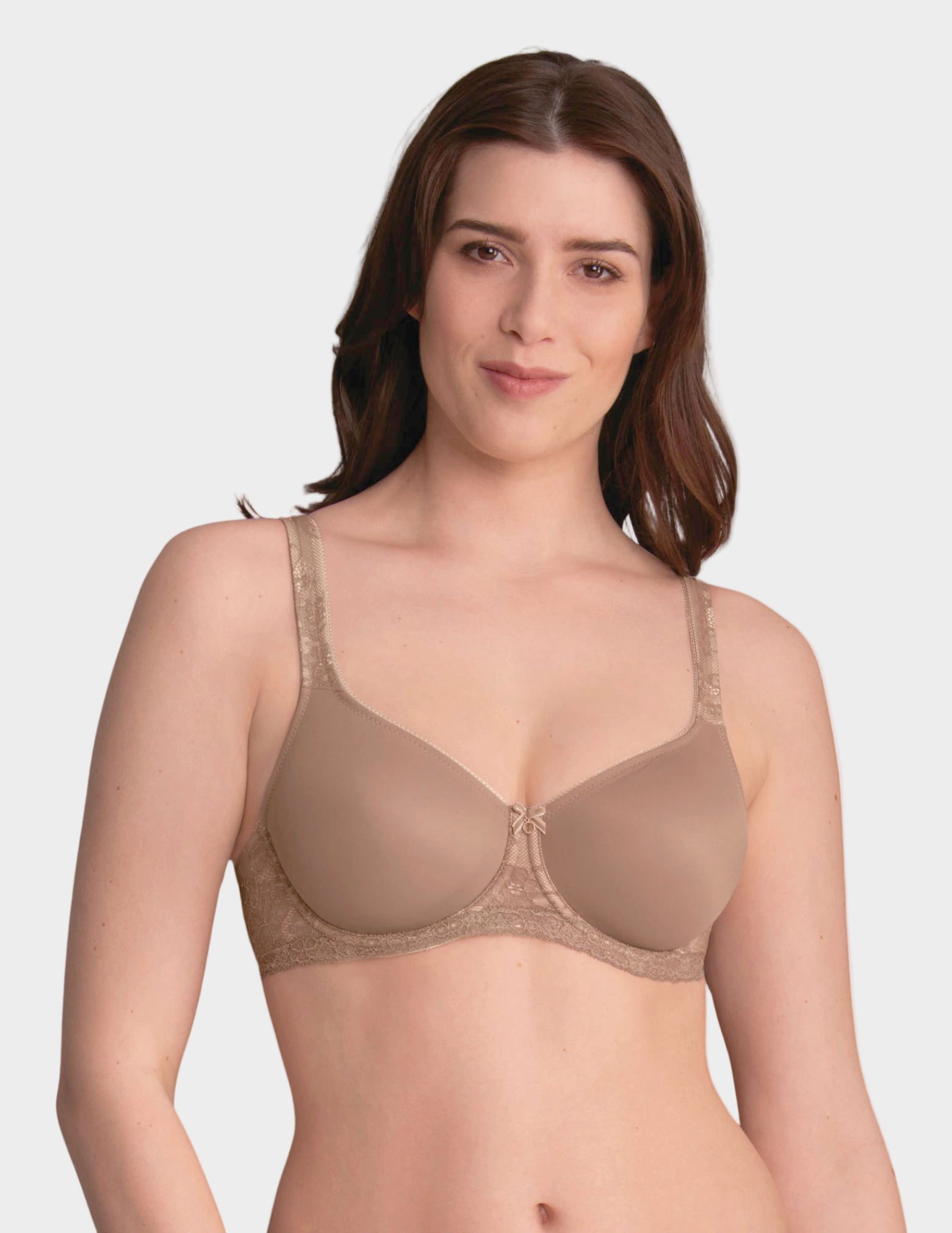 Woman wearing a beige bra on a plain background