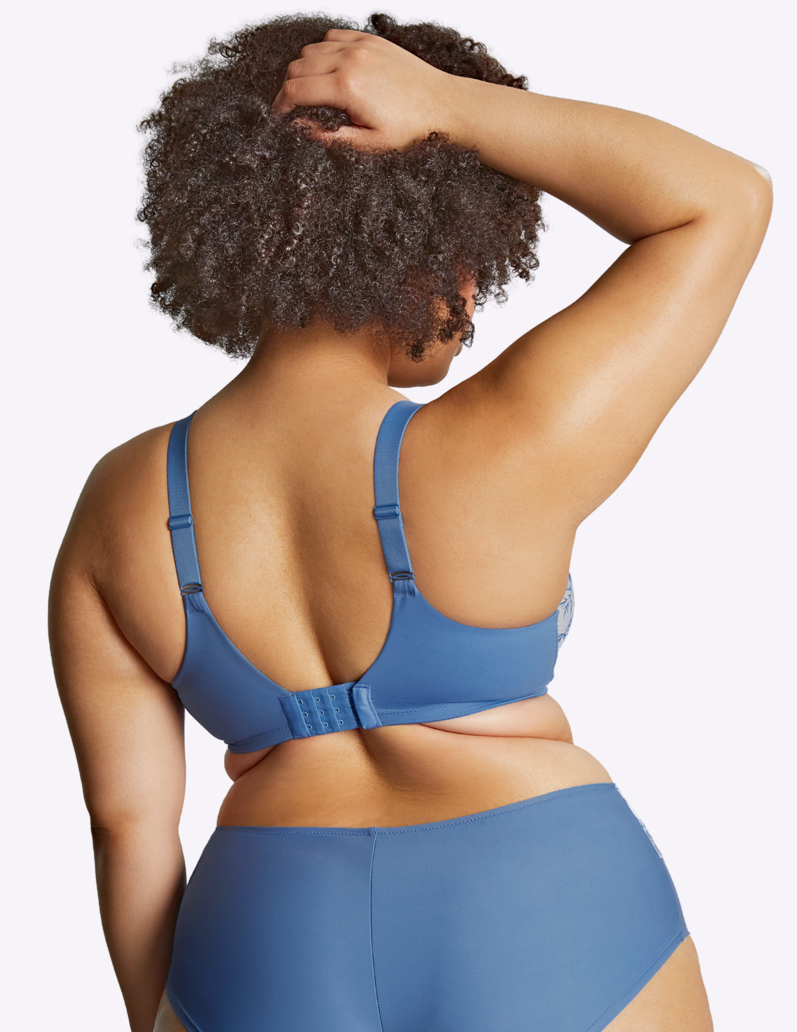 Back view of model wearing bliss bra in blue floral—the back of the bra is completely blue
