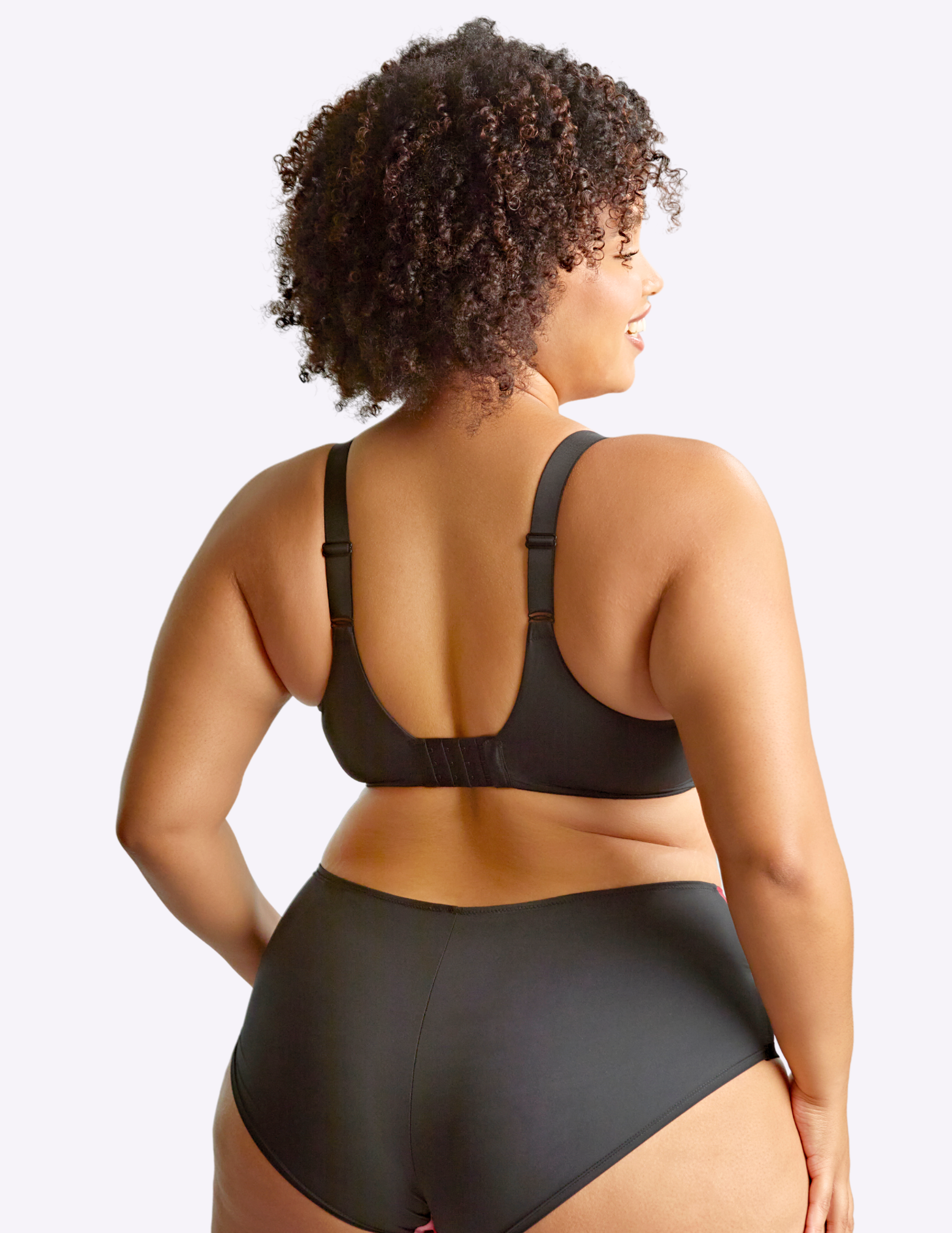 Back view of model wearing bliss bra in rose print—the back of the bra is all black