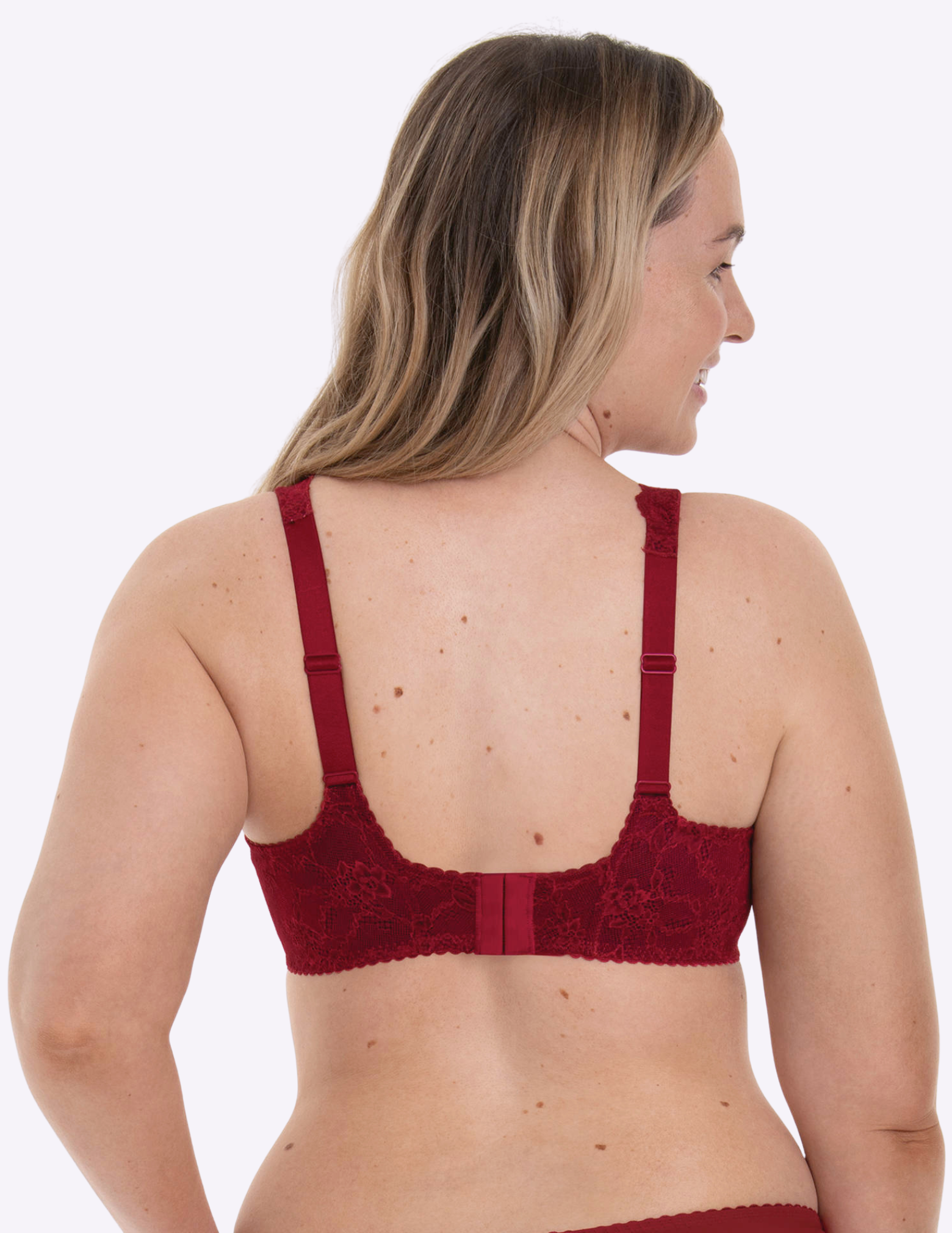 Woman wearing a red lace bra on a white background