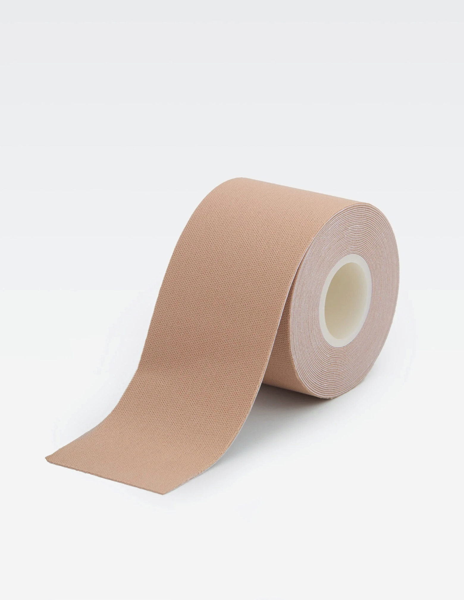 roll of beige body tape on white background