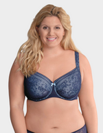 Woman wearing a blue lace bra against a plain background