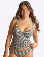 Woman wearing a black and white checkered swimsuit on a plain background
