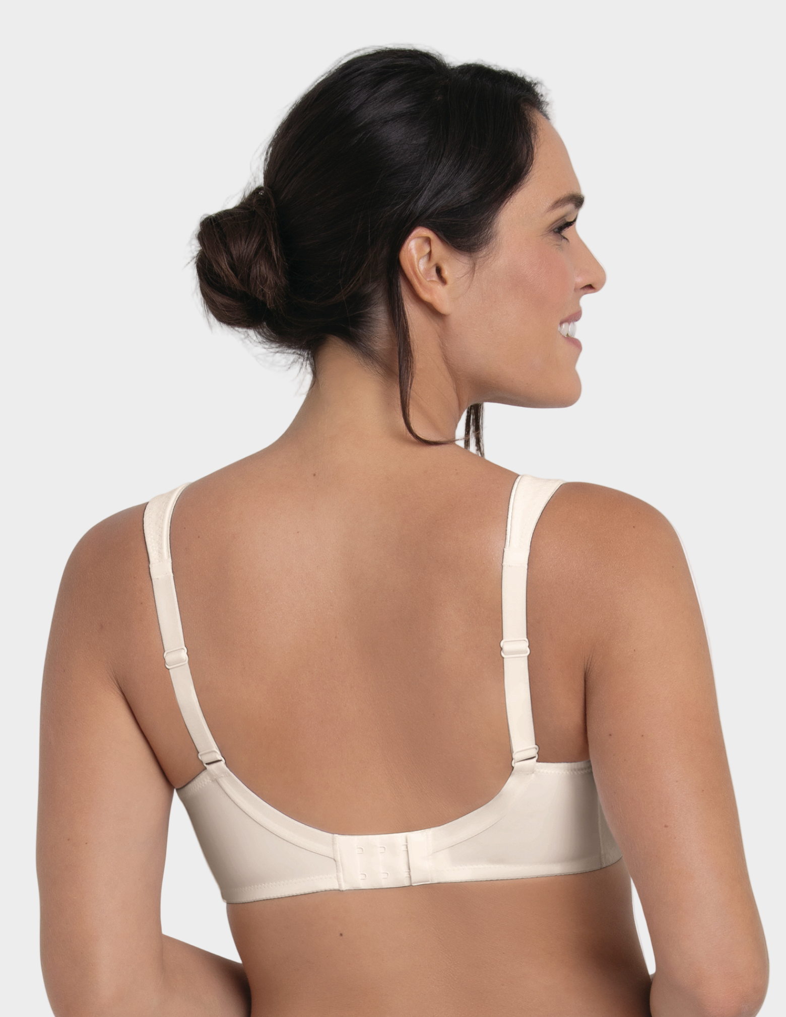 Woman wearing an off white bra against a white background