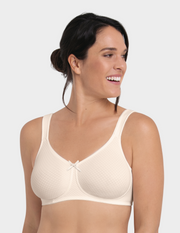 Woman wearing an off white bra against a white background